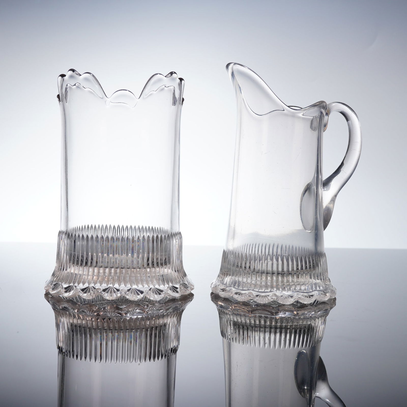 2 EAPG Celery Vase & Creamer Pitcher: A pair of Early American Pattern Glass (EAPG) utility ware items, comprising a celery vase and a small creamer pitcher. Both pieces are executed in clear pressed glass and share a matching decorative