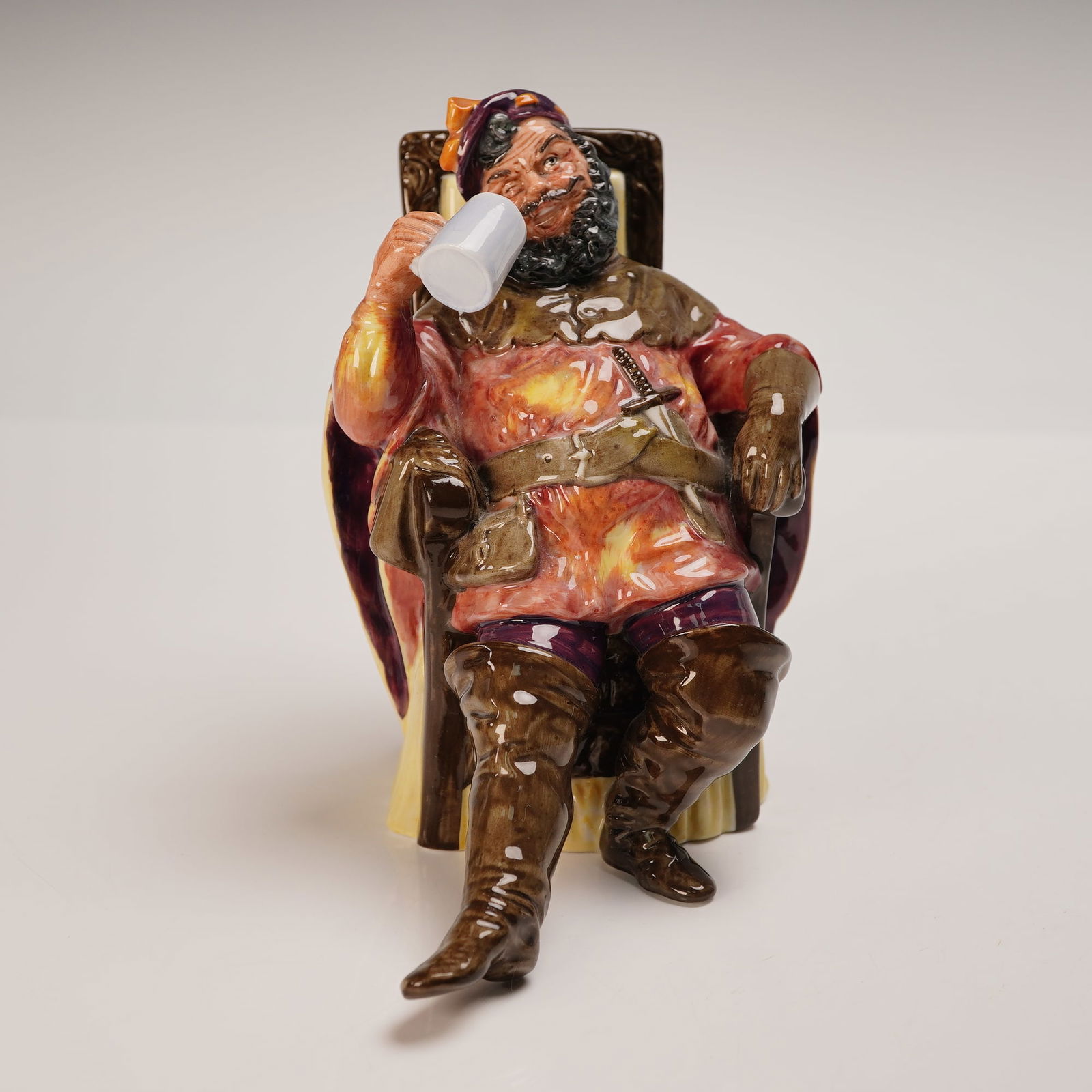 Royal Doulton Figurine, The Foaming Quart HN2162: Royal Doulton porcelain figurine HN2162, The Foaming Quart, introduced in 1954 and modelled by Peggy Davies. This colorful piece depicts a jovial character reclining in a chair, holding a large white