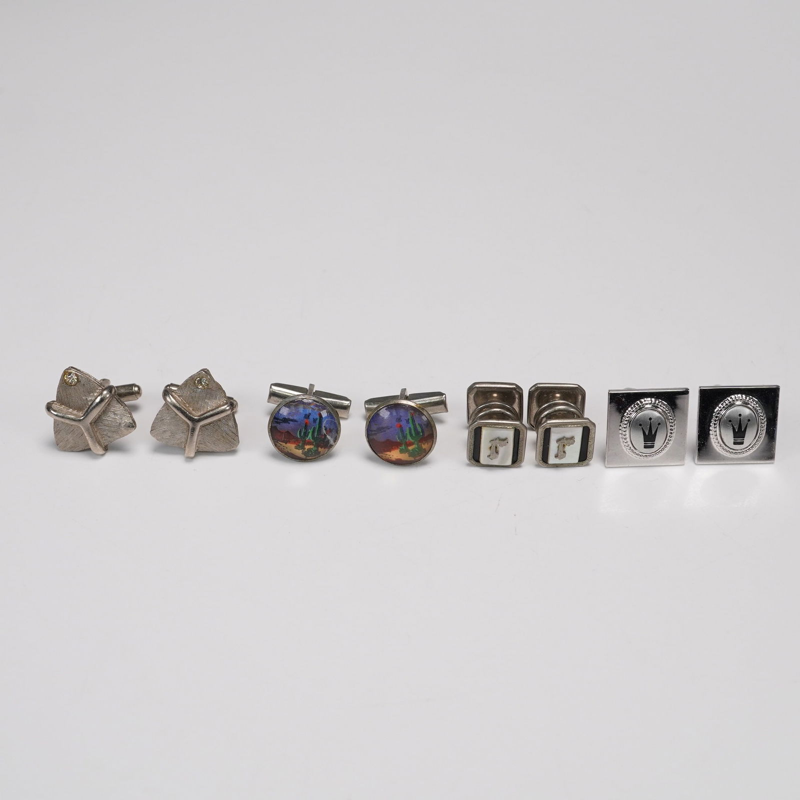 8pc-4pr Vintage Silver Tone Men's Cufflinks Including Crown and Horse Motif: An eclectic grouping of four pairs of vintage silver tone men's cufflinks showcasing mid-century character and design variety. Includes one pair with abstract triangular panels and inset rhinestones,