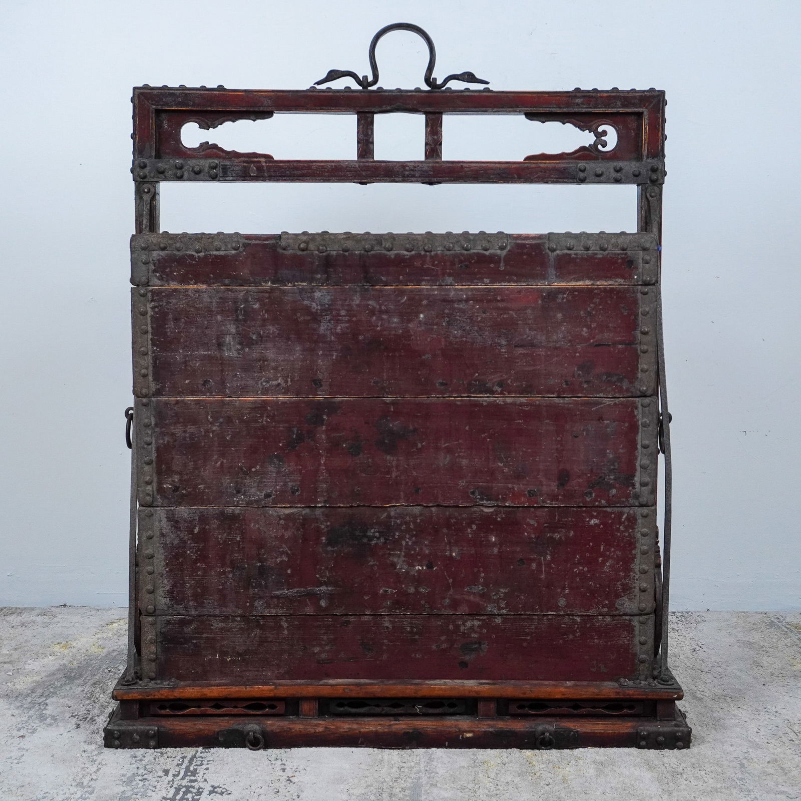 Antique Chinese Tiered Wedding Chest with Iron Hardware: This antique Chinese wooden marriage chest, traditionally used to store dowries or ceremonial gifts, features a robust rectangular design adorned with ornate iron hardware. The chest showcases a rich,