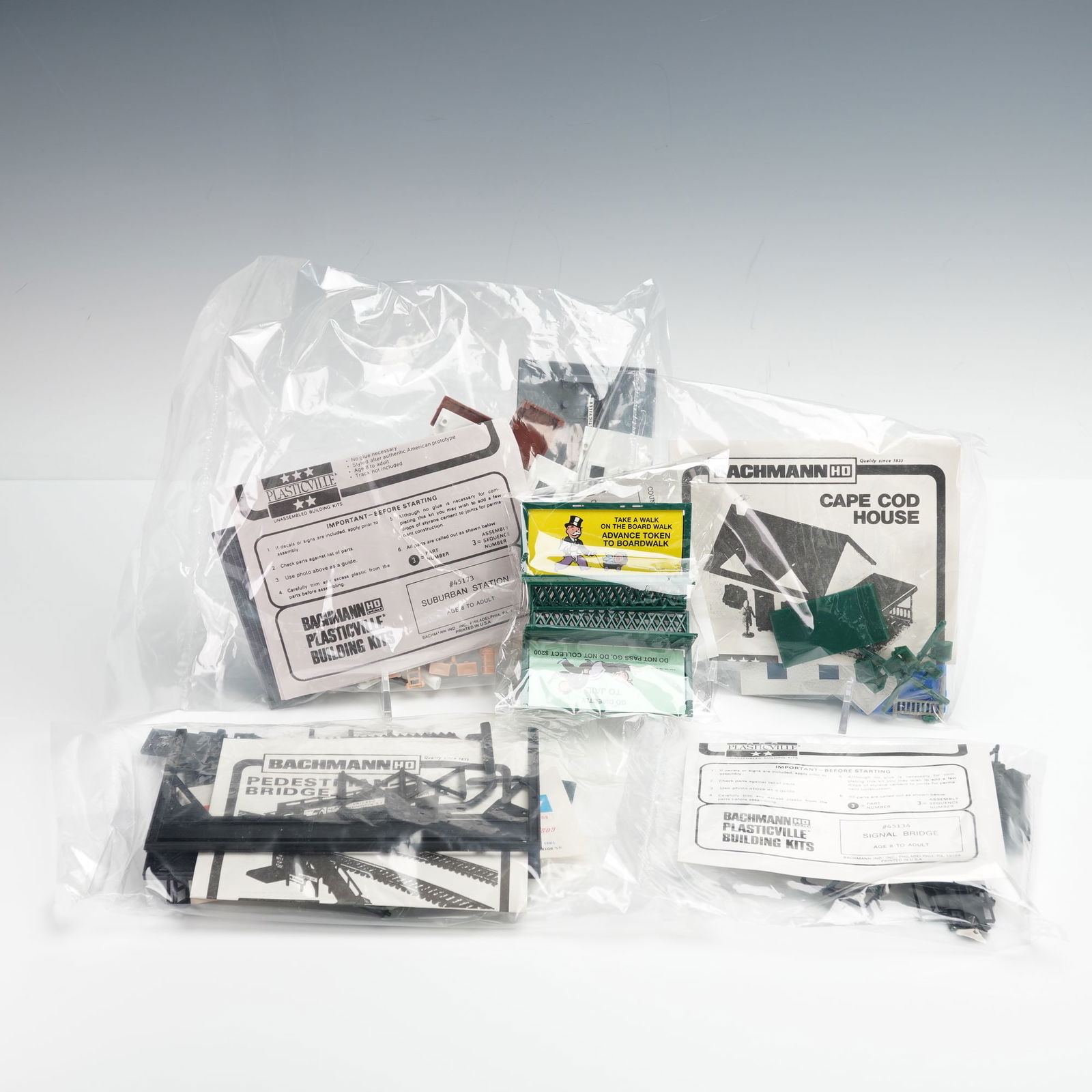 Bachmann Plasticville Building Kits- Signal Bridge, Cape Cod House & More: A collection of unassembled kits in plastic bags; components appear complete with original instructions, including Bachmann HO Plasticville Signal Bridge (#45114), Suburban Station (#45173), Pedestria