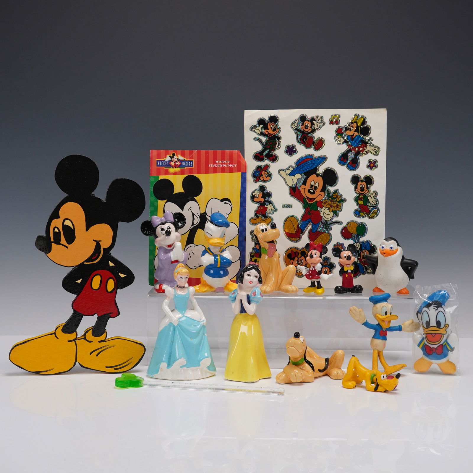 16pc Assorted Disney Figures, Toys and Decals: A group of 16 assorted Disney themed items including ceramic and plastic figures, a Mickey Mouse finger puppet, sticker sheet, and painted wooden cut out. Characters include Mickey Mouse, Minnie Mouse