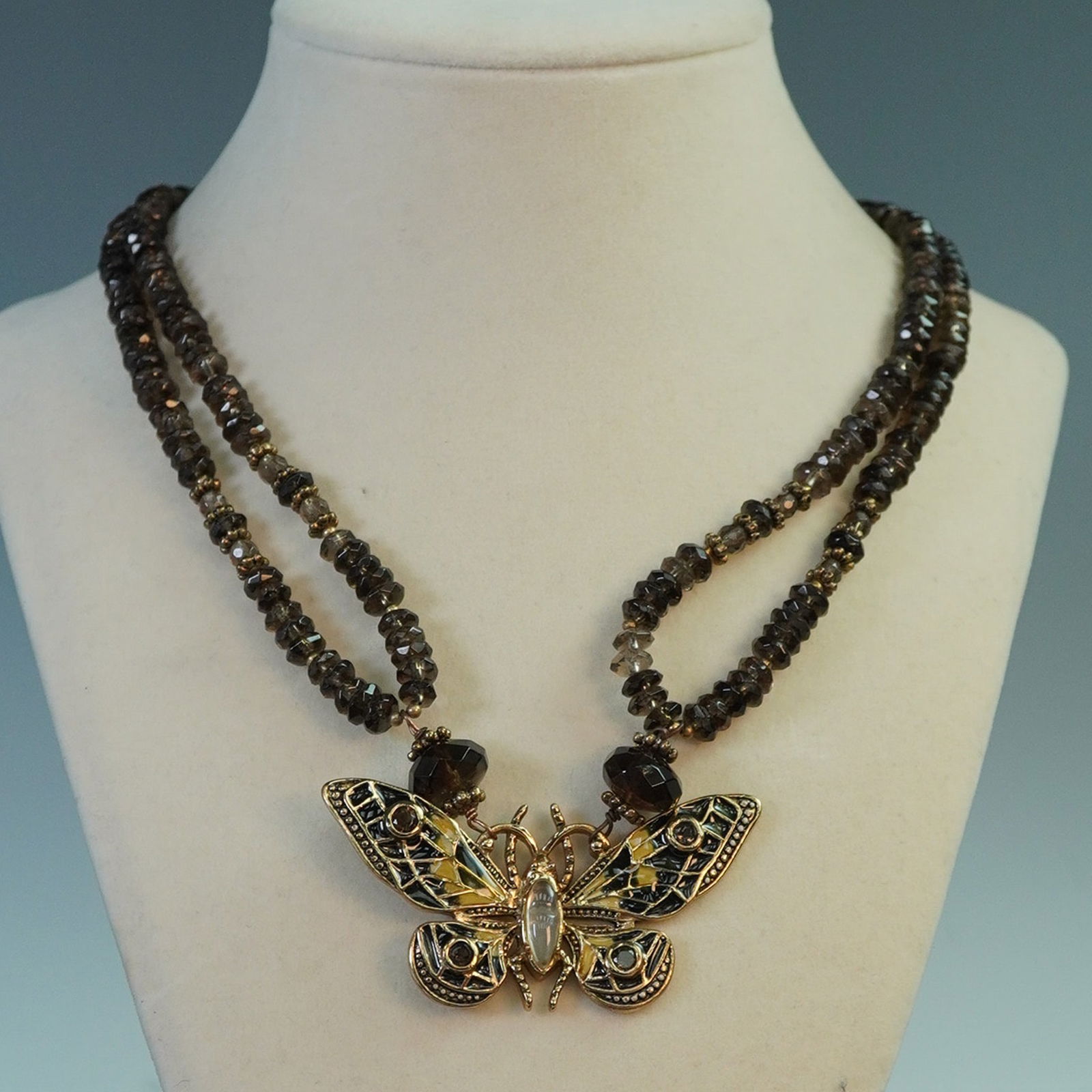 Amy Kahn Russell Smoky Quartz Necklcae: Designer double strand necklace by Amy Kahn Russell, featuring polished smoky quartz beads and a detailed cloisonne butterfly pendant. Known for her distinctive use of natural stones and global influe