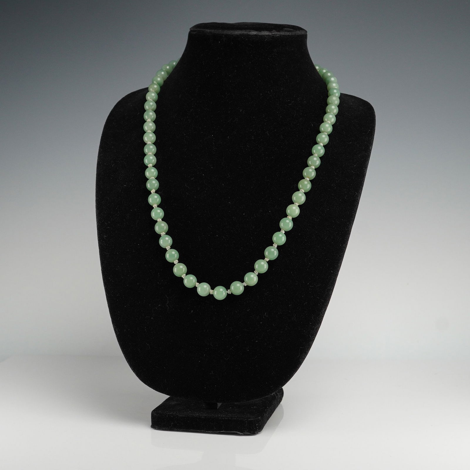 Green Aventurine Bead Necklace with Silver Clasp: This vintage strand features polished green aventurine beads, uniformly hand-knotted and exhibiting a soft, natural translucence with subtle mineral inclusions. The necklace fastens with a delicate ov