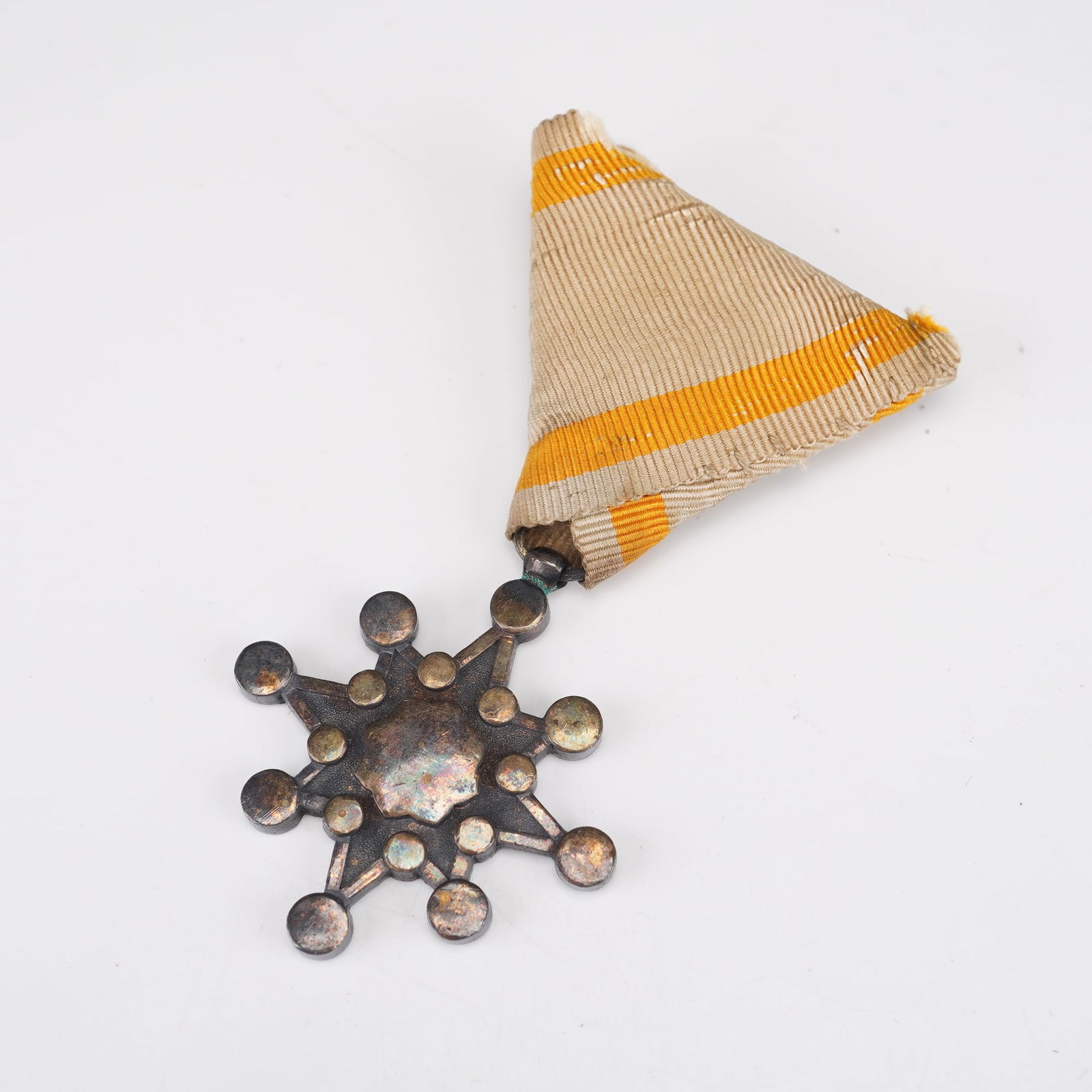 Japanese Fire Brigade Service Medal in Lacquered Presentation Case: A Japanese Fire Brigade Service Medal housed in its original lacquered wooden presentation case with gilt script to the lid. The medal features a radiating multi-point star design with circular finial