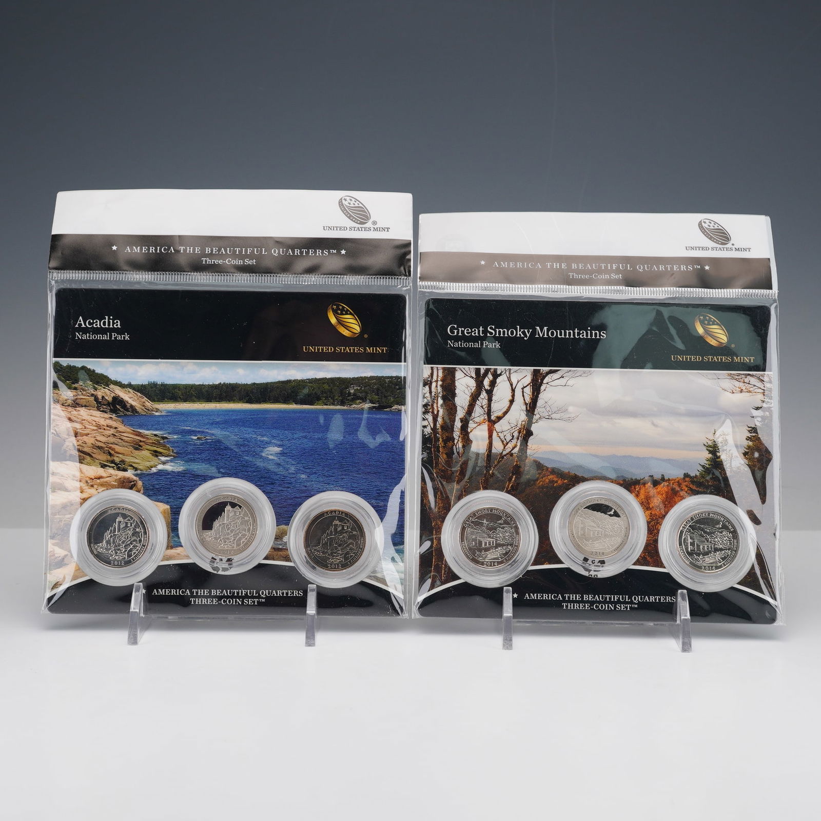 2pc 2012, 2014 America the Beautiful Three-Coin Quarters Sets: America the Beautiful Quarters three-coin sets, featuring Acadia National Park (2012) and Great Smoky Mountains National Park (2014). Each set includes three versions of the same commemorative