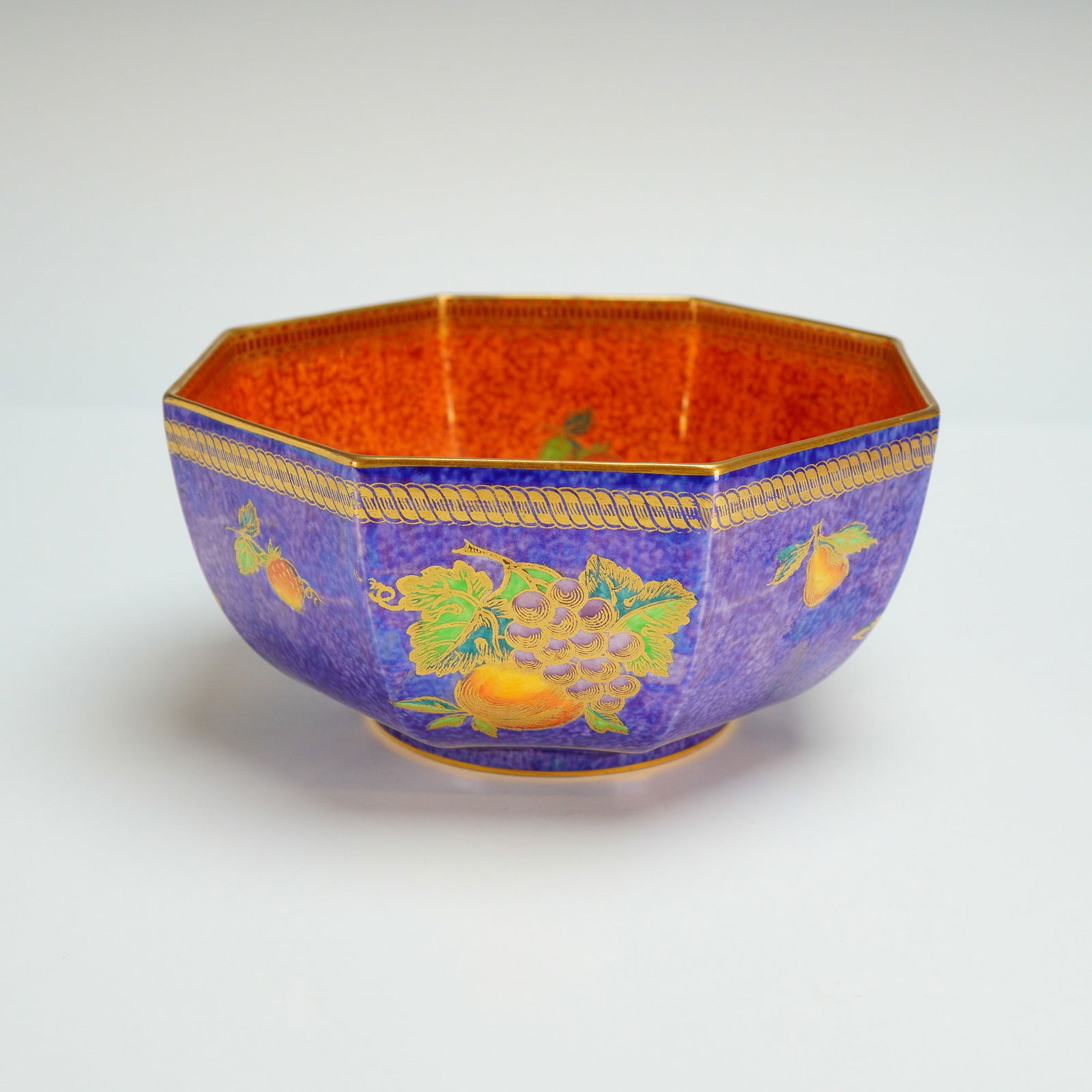 Wedgwood Fairyland Lustre Octagon Bowl, Blue Fruit Z5457: Designed by Daisy Makeig-Jones (British, 1881-1945). The interior and exterior are decorated with a polychrome fruit cluster including strawberries, pears, grapes, and peaches, finished in an orange-c