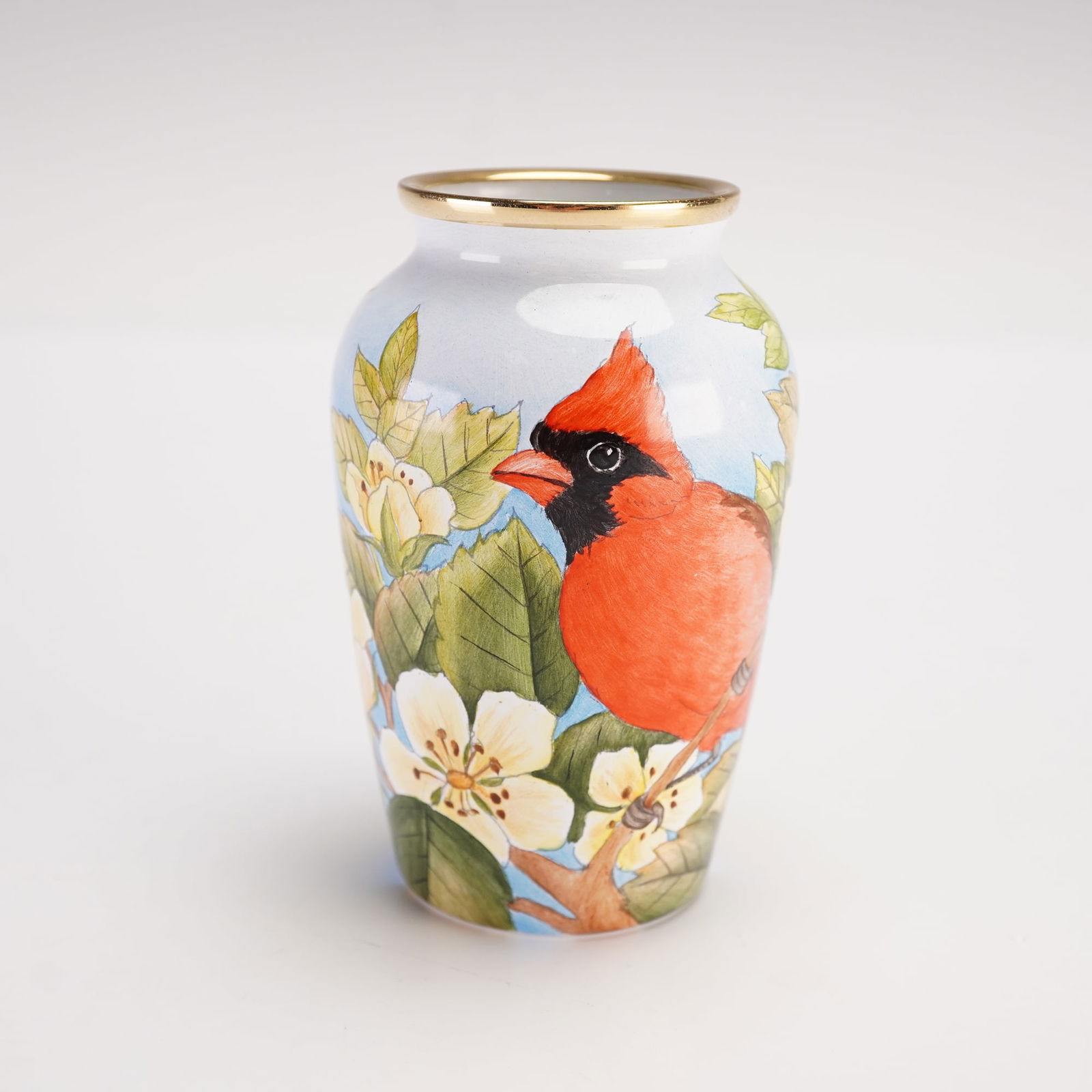 Moorcroft Enamels Miniature Vase, American Red Cardinal: Handcrafted enamelware miniature vase featuring a stylized depiction of the American Red Cardinal rendered against a mottled ground. "CS" marked to underside. Designed in a numbered edition. Moorcroft
