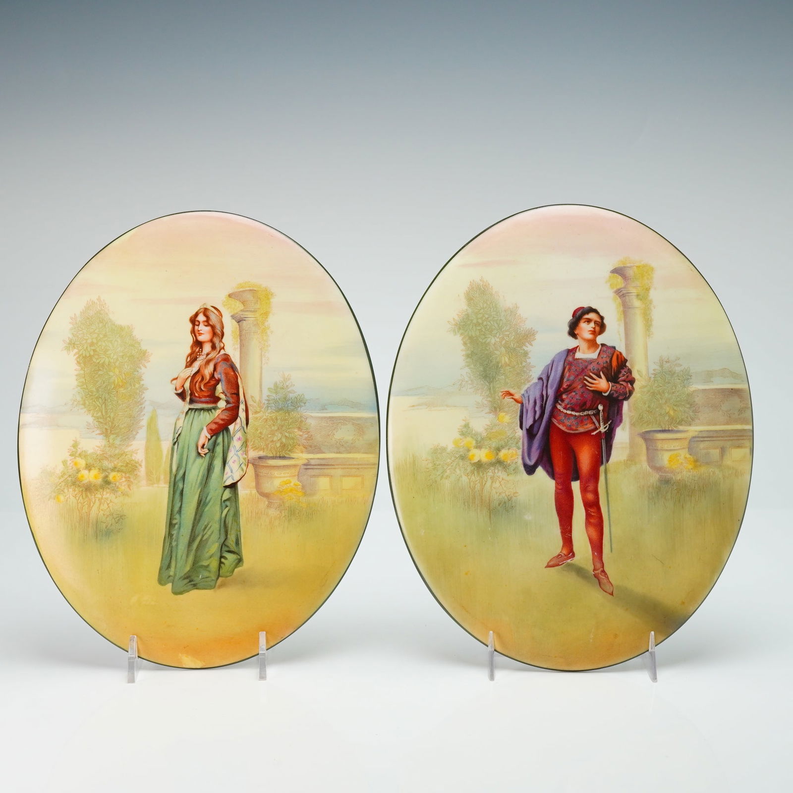 2pc Royal Doulton Porcelain Plaques, Romeo & Juliet: Two oval tile plaques designed in soft coloration of Romeo and Juliet in garden scenes. Royal Doulton backstamp. Dimensions: 7.5"L x 9.5"H Country of Origin: England Weight: 3.2 lbs.