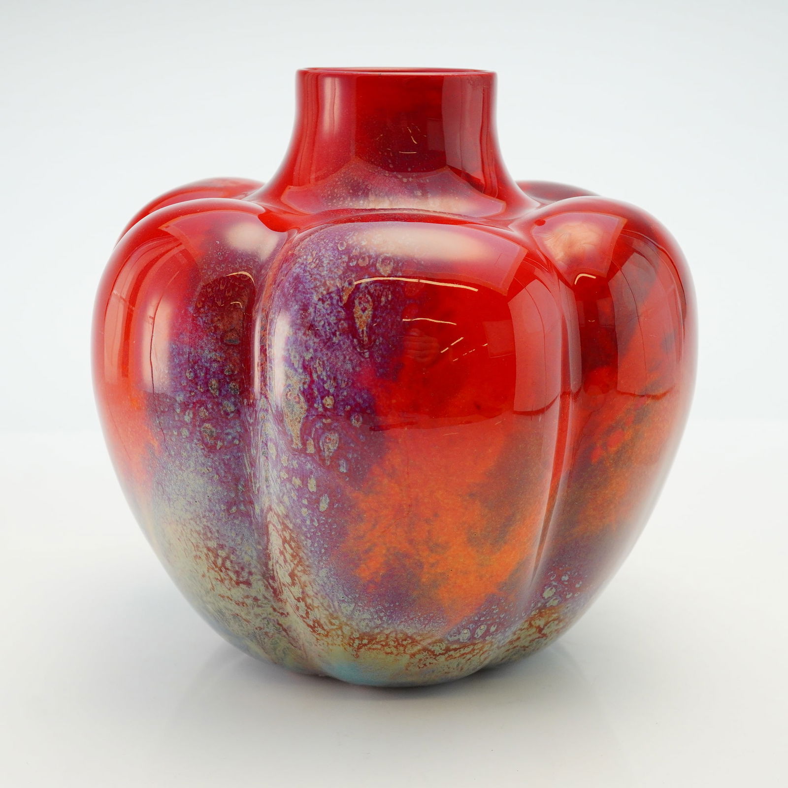 Royal Doulton by Charles Noke and Fred Moore Sung Flambe Pumpkin Vase: Designed by Charles Noke and Fred Moore, this pumpkin-shaped vase colored in deep red with blue, orange, white, and purple. Royal Doulton Flambe backstamp. Charles Noke and Fred Moore artist marks on