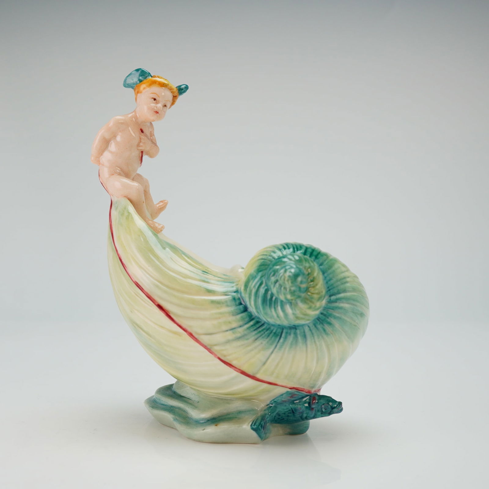 Minton Les Enfants De La Mer Figurine, L'Enfant Au Chariot: A limited edition figure of a cherub riding on top of a large white nautilus shell with green highlights. Minton backstamp. Issued: 2002 Dimensions: 4.5"L x 6.25"H Edition Number: 20 of 500 Country of