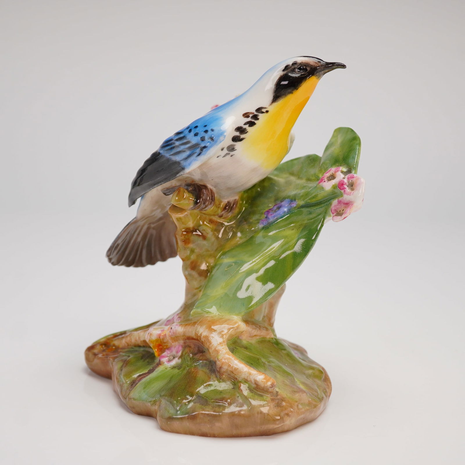 Royal Doulton Bone China Figurine Yellow Throated Warbler HN 2546: A single glazed bone china figurine produced by Royal Doulton, titled Yellow Throated Warbler, model number HN 2546. The figure depicts the namesake bird perched upon a naturalistic tree trunk base. T