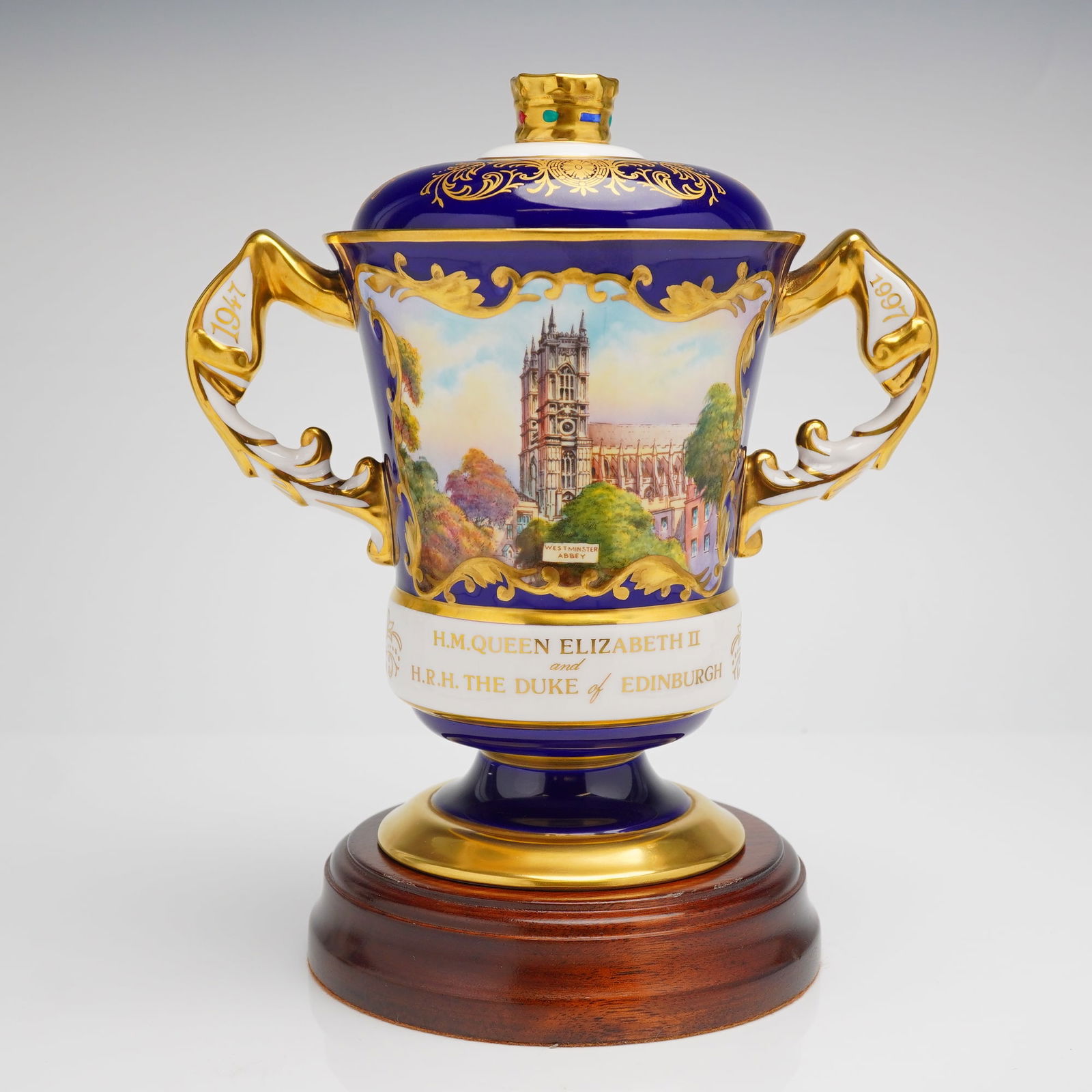 Aynsley The Westminster Abbey Bone China Lidded Vase with Base: The lot comprises a limited edition Aynsley Fine Bone China lidded trophy vase, known as The Westminster Abbey Vase, and its accompanying Certificate of Authenticity. The vase is crafted with a cobalt