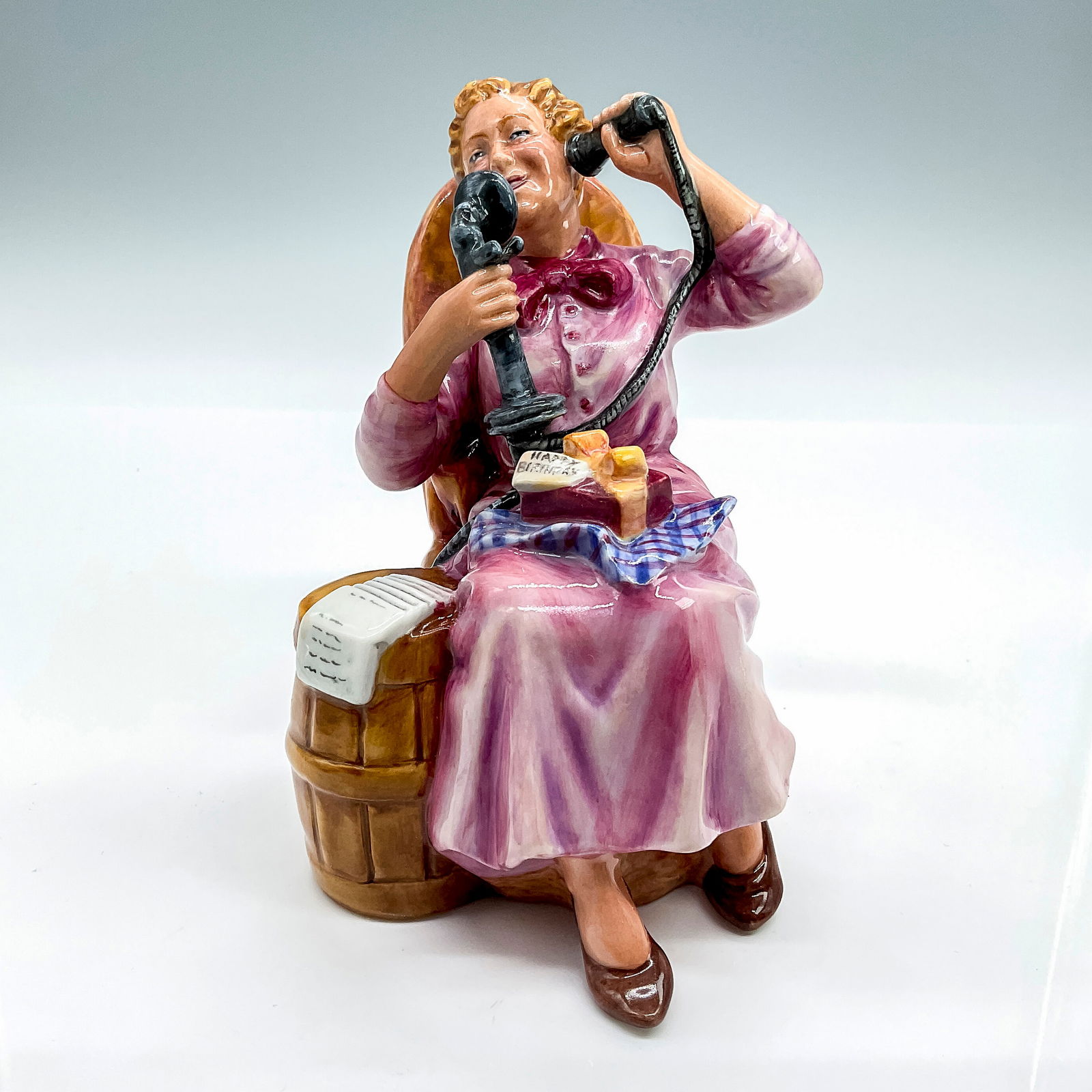 Royal Doulton Prototype Figurine, Hello Darling: Glossy finish figure modeled as a seated lady, smiling gracefully as she wishes a happy birthday on the telephone. Royal Doulton backstamp. Dimensions: 3.5-L x 4.5-W x 5.5-H Country of Origin: England