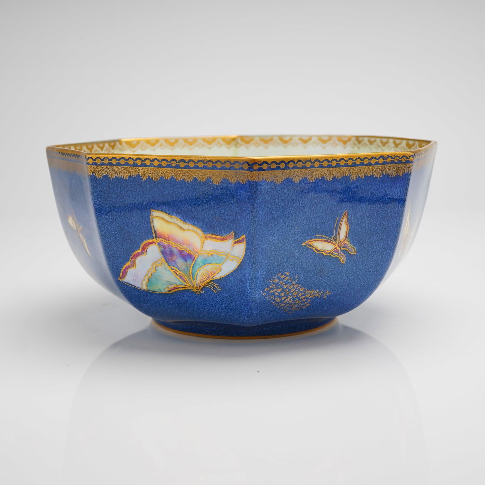 Wedgwood Fairyland Lustre Butterfly Octagonal Bowl Z5068: A single octagonal ceramic bowl attributed to Daisy Makeig-Jones for Wedgwood, England, utilizing the specialized lustre technique often associated with the Fairyland line. The exterior features a dee