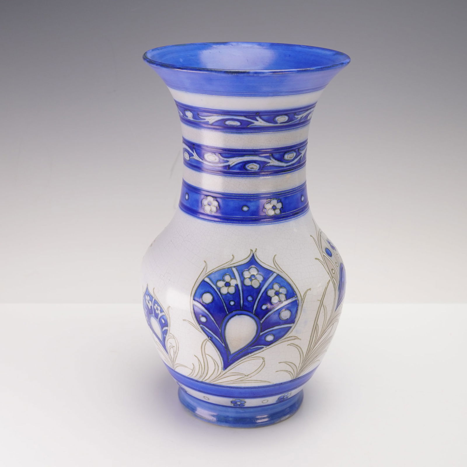 William Moorcroft Pottery Vase, Peacock Feathers: Finely crafted vessel decorated with tube lined peacock feathers motif to the main body. Finished with painted blue interior. Signed W. Moorcroft to underside. Artist: William Moorcroft Issued: c. 193