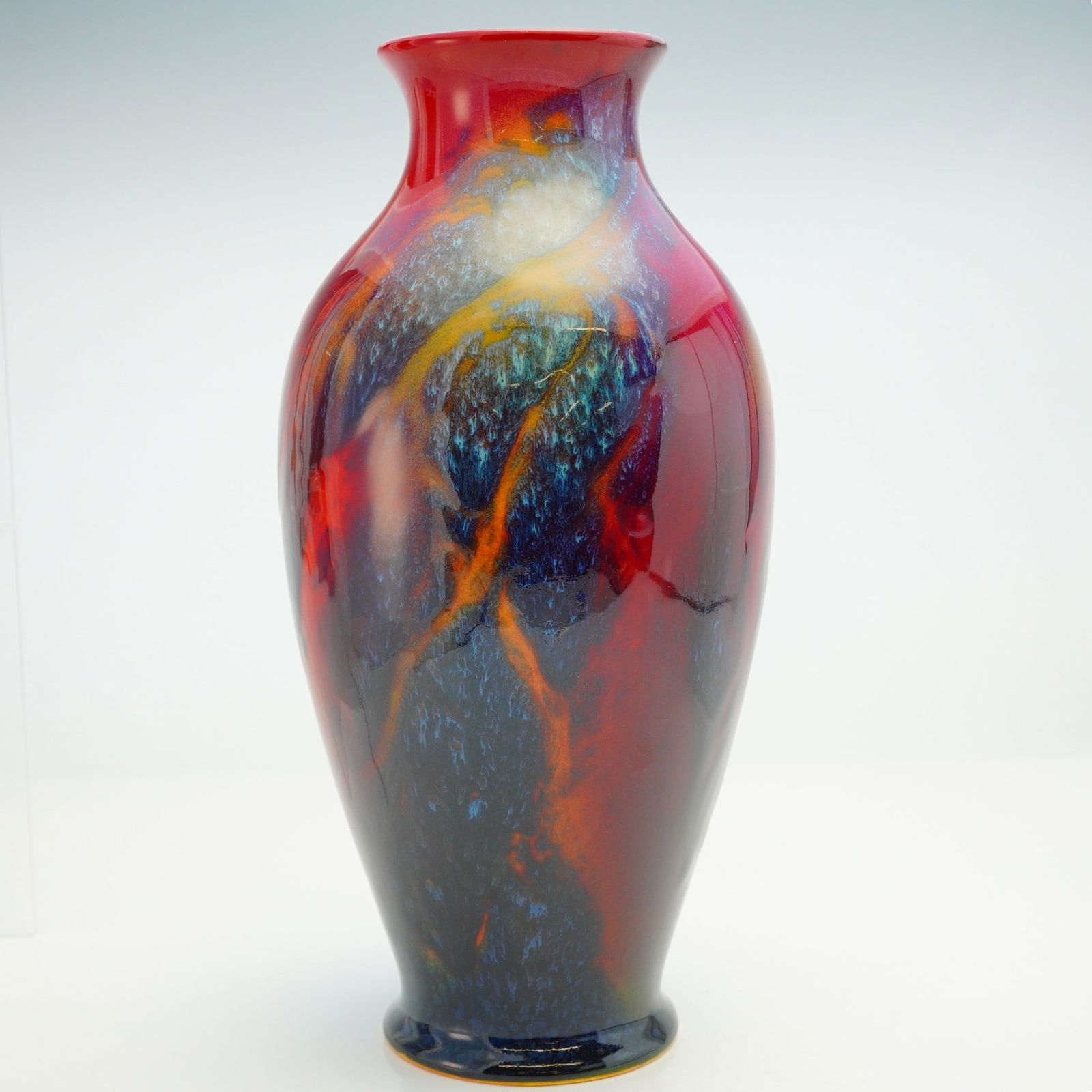 Royal Doulton Flambe Sung Vase by Charles Noke: Red glaze with mottled blue, green and orange with a wide opening at the top. Royal Doulton Flambe and Noke backstamp on base. Dimensions: 5"W x 10"H Country of Origin: England Weight: 2.2 lbs.