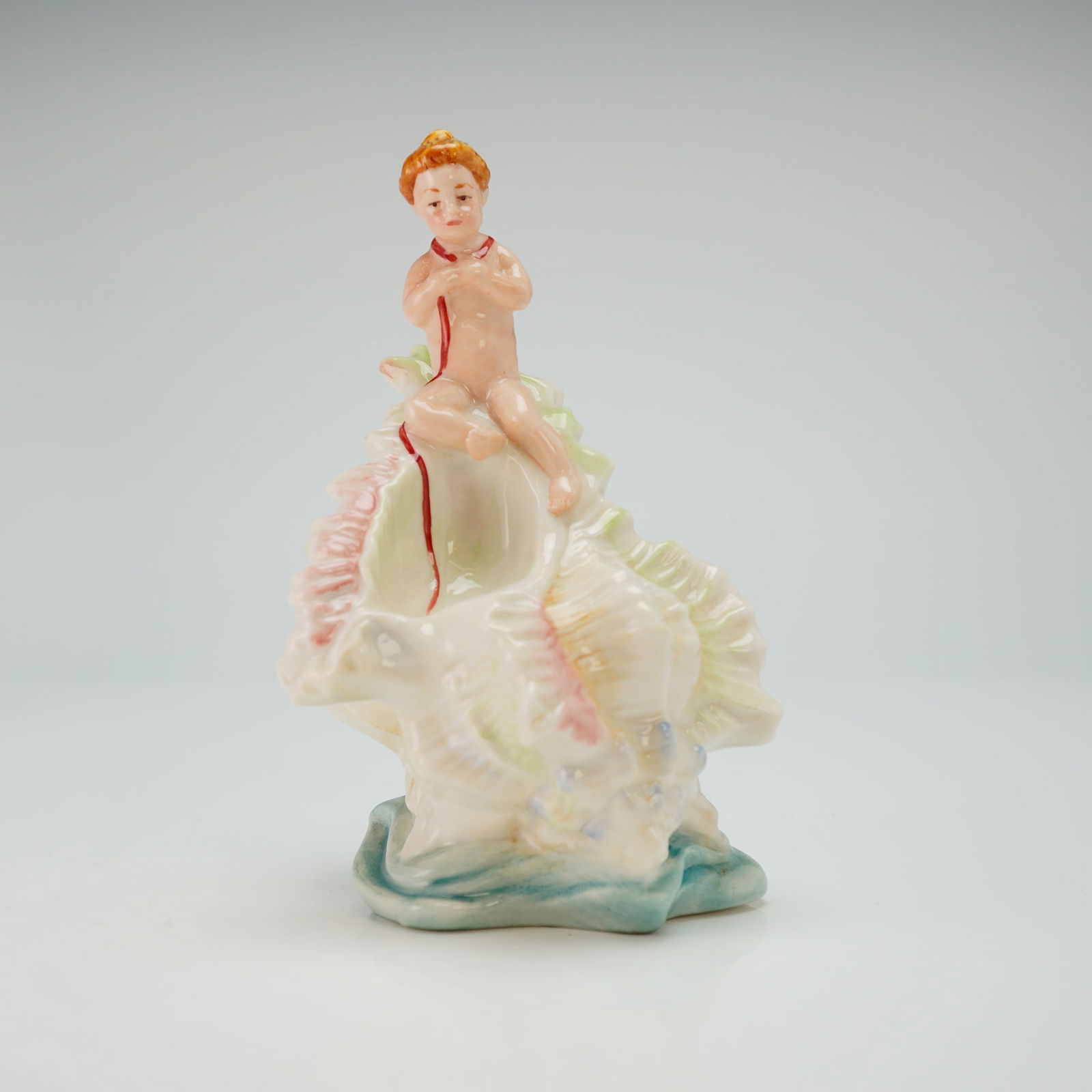 Minton Les Enfants De La Mer Figurine, L'Enfant Aux Rubans: A limited edition figure of a cherub ridding on top of a large white conch shell with pink highlights. Minton backstamp. Issued: 2002 Dimensions: 4"L x 6"H Edition Number: 29 of 500 Country of Origin: