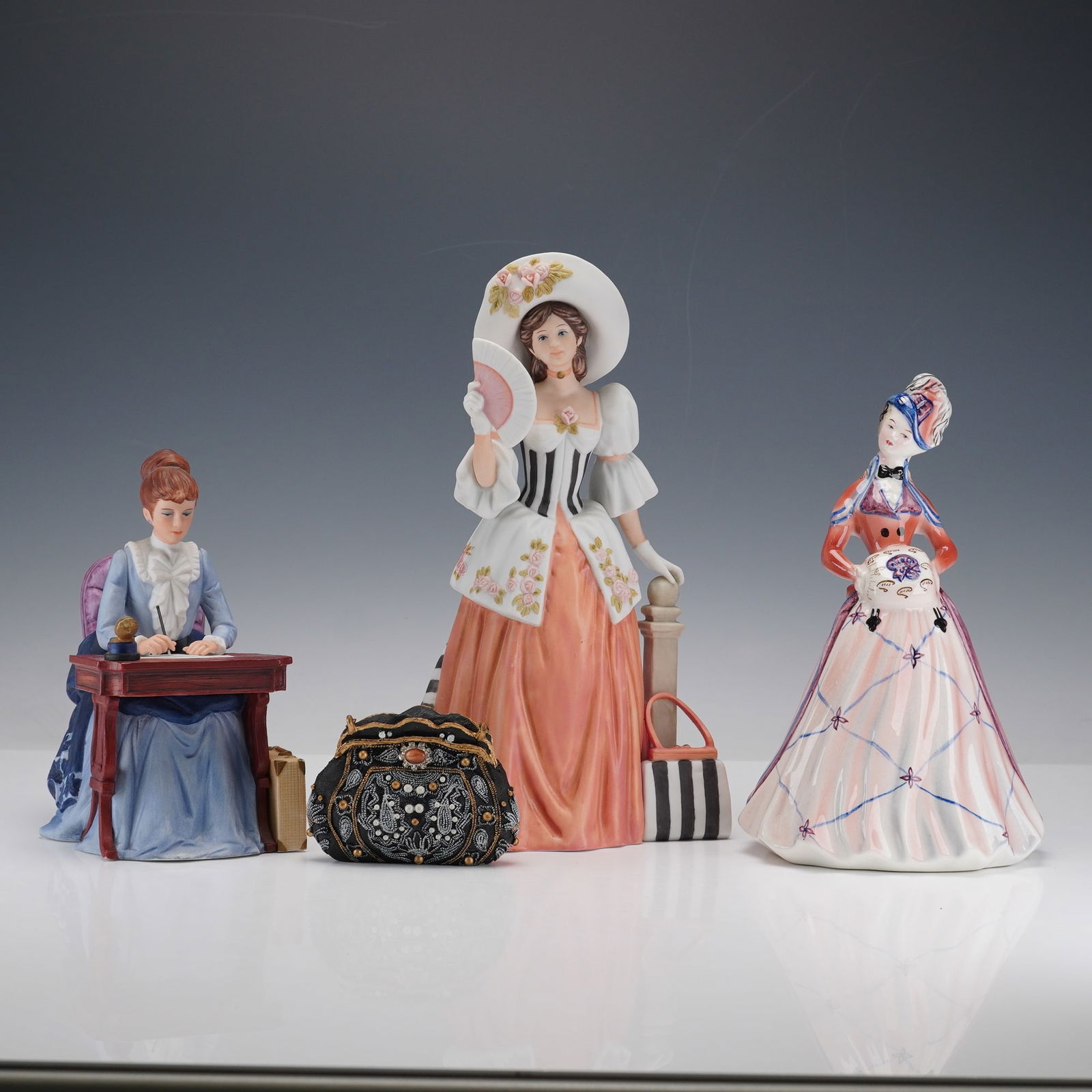 4pc Avon Products, Goldscheider, and Popular Imports Figurines: This elegant four piece collection includes a Goldscheider Winter figurine, two Avon Albee Award figurines, and a Popular Imports decorative handbag figurine. The Goldscheider piece portrays a gracefu