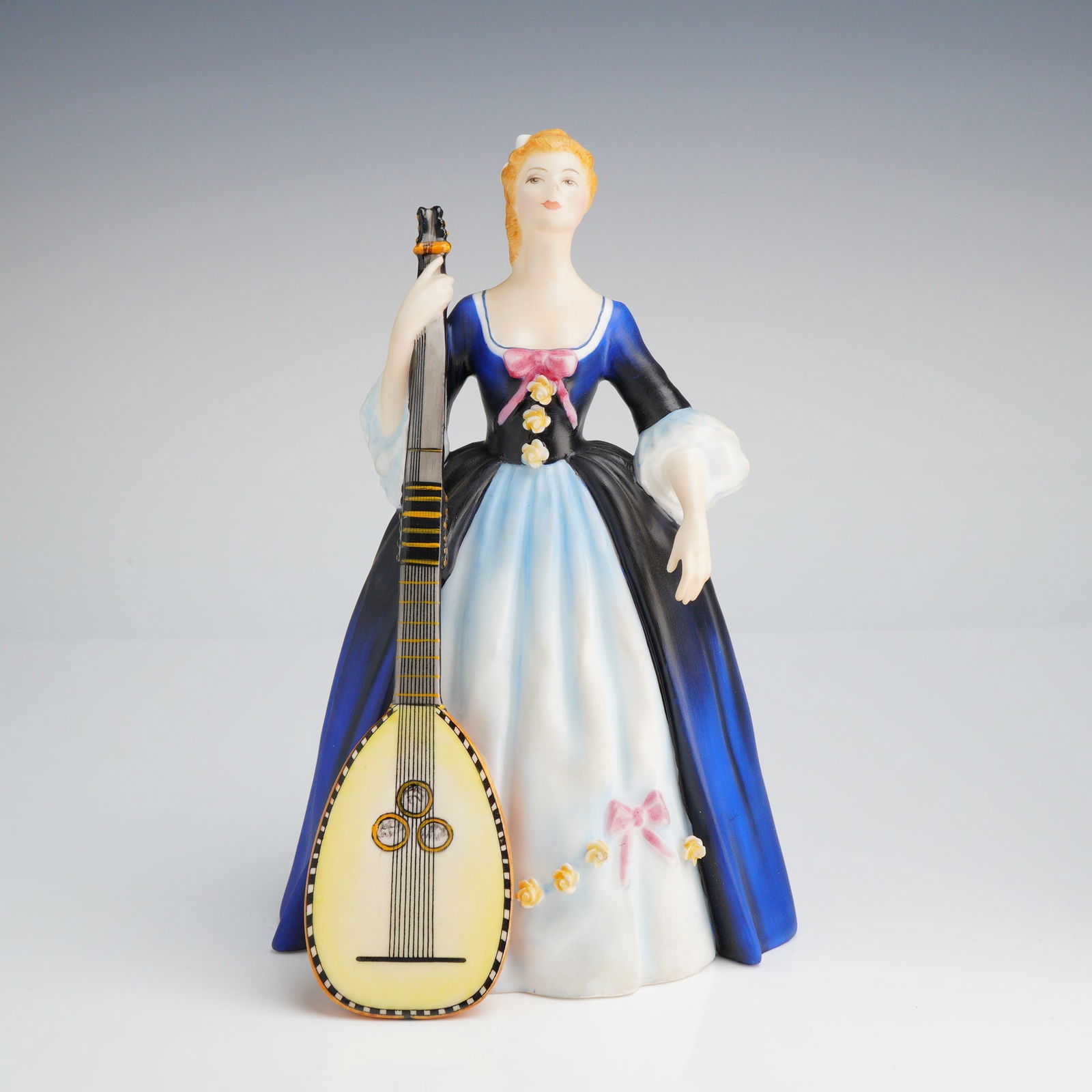 Royal Doulton Figurine, Chitarrone HN2700: A Royal Doulton bone china figurine titled Chitarrone, model H.N. 2700, from the Lady Musicians series. Modeled by Peggy Davies and dated 1973, the figure depicts a woman in 18th-century style dress s