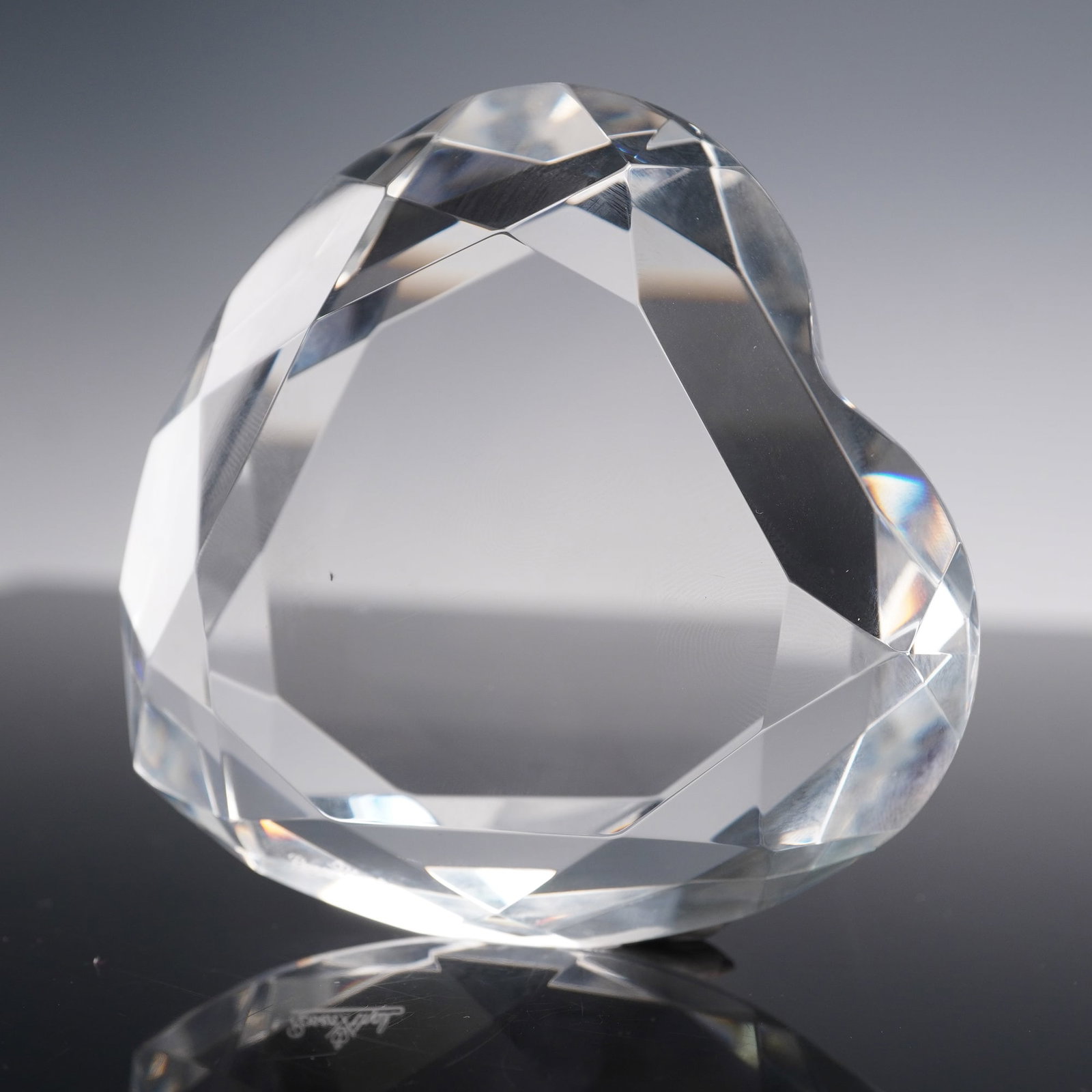 Rosenthal Crystal Heart Paperweight: Crafted from clear lead crystal, the piece features multiple angular cuts that create brilliant refraction's of light and a smooth polished surface. The underside bears an etched Rosenthal signature.