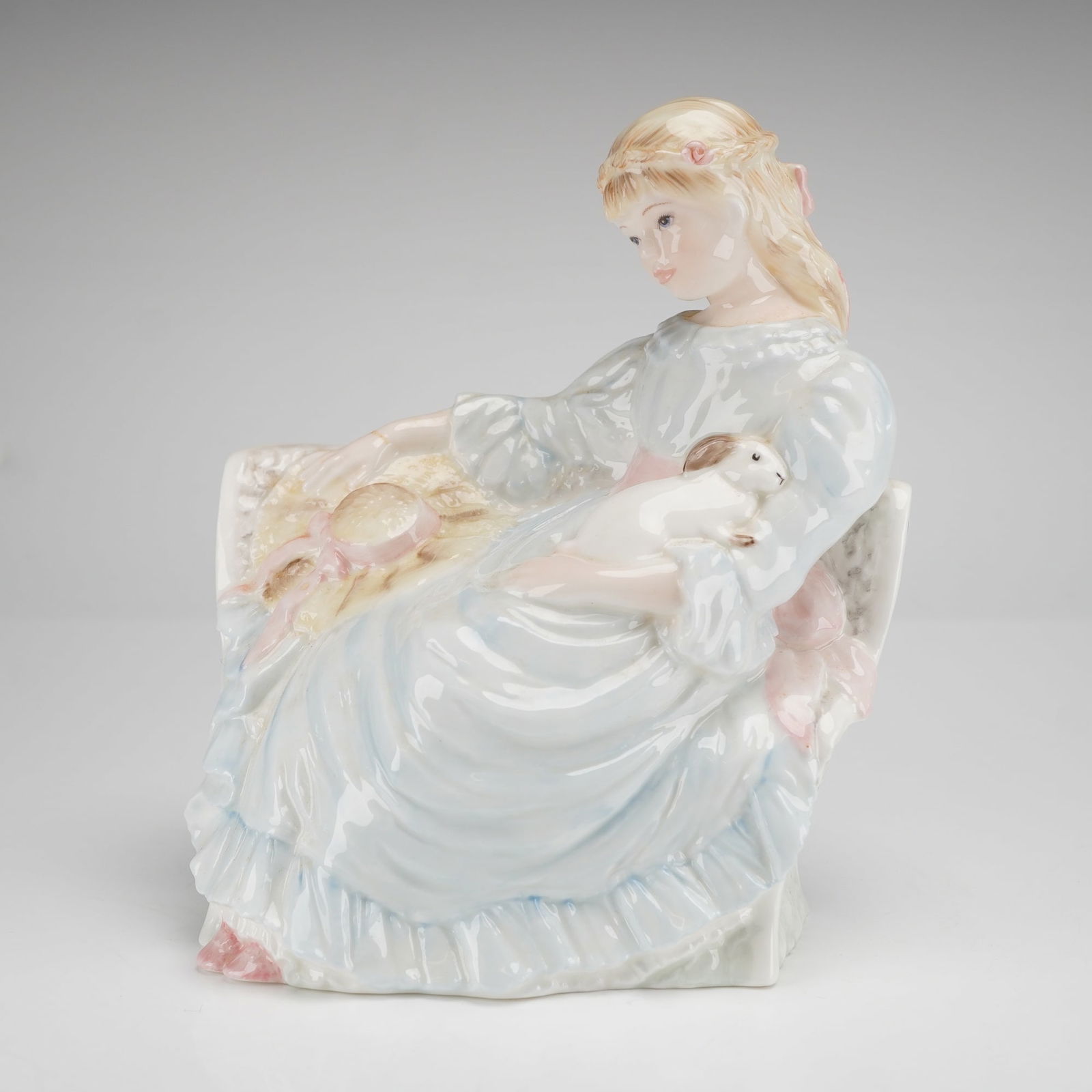 Coalport Bone China Figurine, Summer Daydream: This limited-edition piece, numbered 1,569 of 9,500, was sculpted by Sheila Mitchell for Compton & Woodhouse Ltd. The figurine depicts a seated young girl with blonde hair tied with a pink ribbon, wea