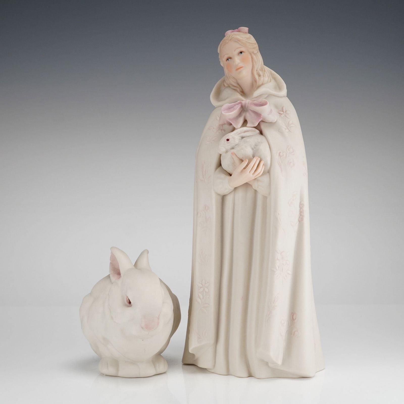 Two Cybis Porcelain Figurines Melissa and Mr. Snowball: A two-piece set of Cybis bisque porcelain figurines, identified as Melissa and Mr. Snowball from the Children to Cherish series. The set includes the figure of Melissa, a young woman, and a separate c