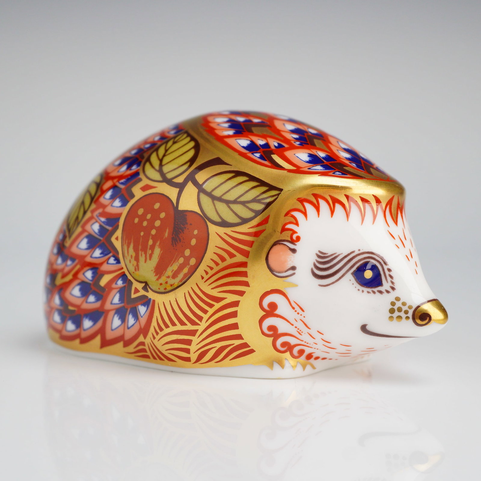 Royal Crown Derby Orchard Hedgehog Paperweight: Royal Crown Derby Orchard Hedgehog bone china paperweight. This piece is modeled in the form of a hedgehog and decorated in an Imari-inspired palette of iron red, cobalt blue, and gold gilding. The de