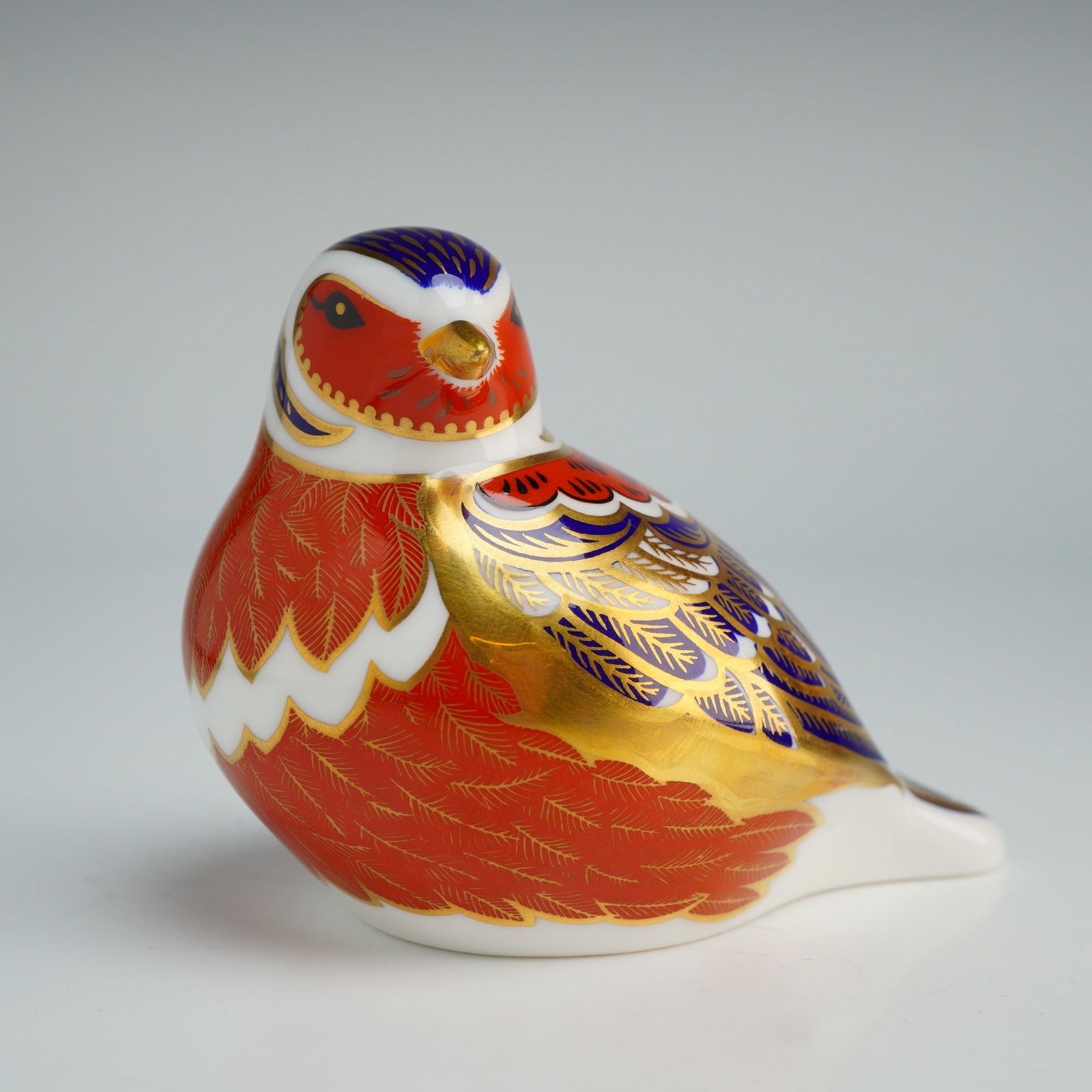 Royal Crown Derby Paperweight, Chaffinch with Box: A Royal Crown Derby fdepicting a chaffinch in the traditional Imari style. The figurine is decorated with cobalt blue and iron-red glazes, accented with 22-carat gold gilding defining the feather patt
