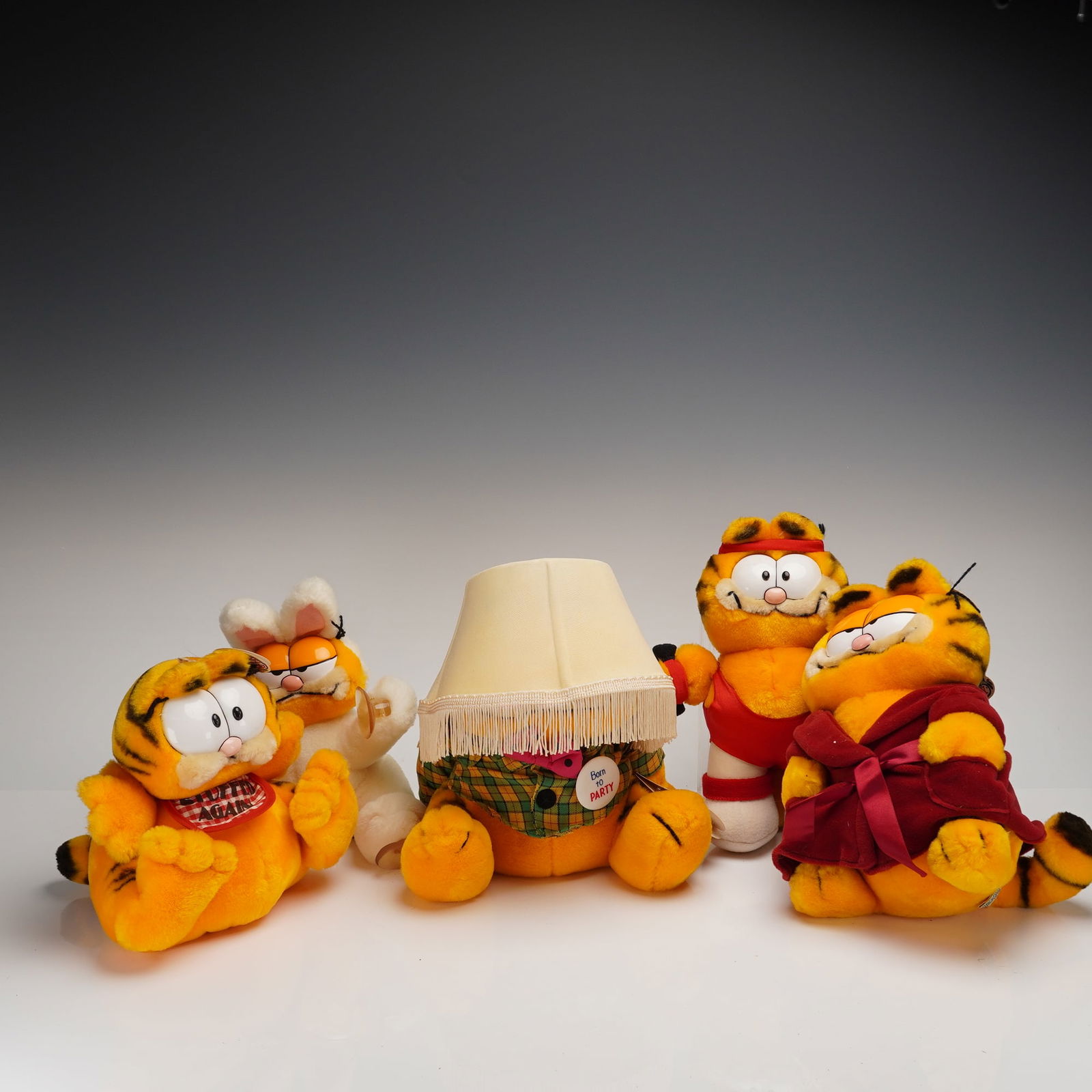 A Collection of Five Vintage R. Dakin & Company Garfield Plush Toys: A collection of five vintage stuffed plush toys depicting the comic strip character Garfield, manufactured by R. Dakin & Company, San Francisco, CA. The toys are constructed from orange and black stri