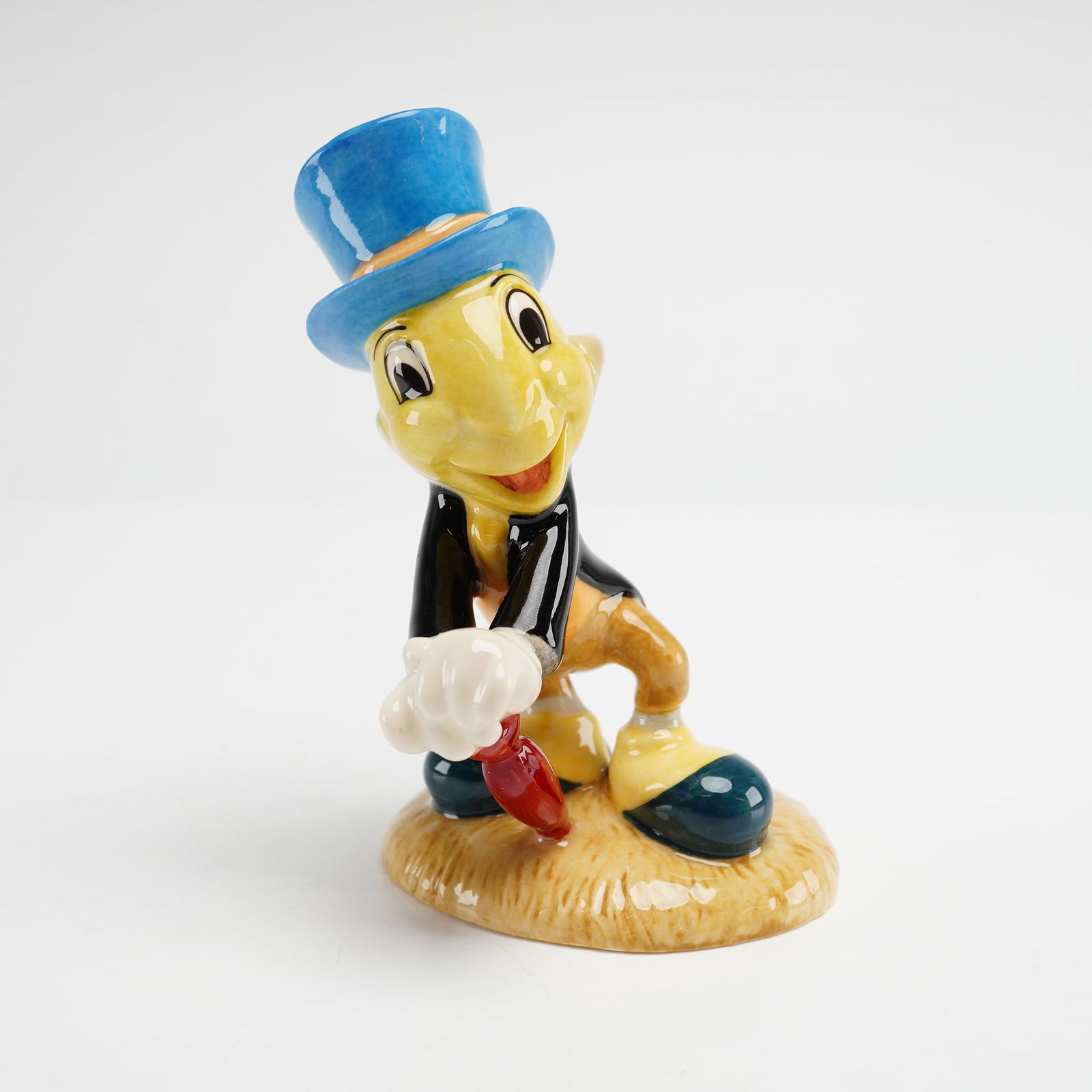 Royal Doulton Disney Figurine, Jiminy Cricket FC5: A Royal Doulton Disney Showcase Collection hand-decorated porcelain figurine of Jiminy Cricket, model FC5, from the Film Classics series. Modeled by Warren Platt and dated 2000, the figure is depicted