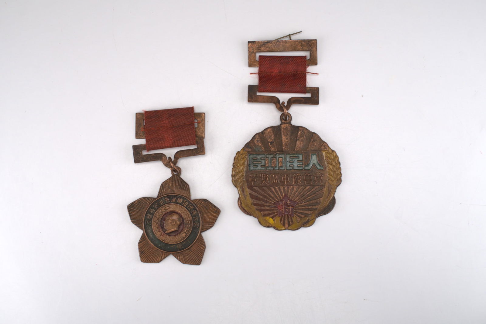 2pc Chinese Military Award & Chairman Mao Award Committee Medals: Two Chinese award medals comprising one scalloped circular bronze-finish medal dated 1948 on the reverse, featuring enameled Chinese characters on the obverse with a radiating sunburst motif flanked b