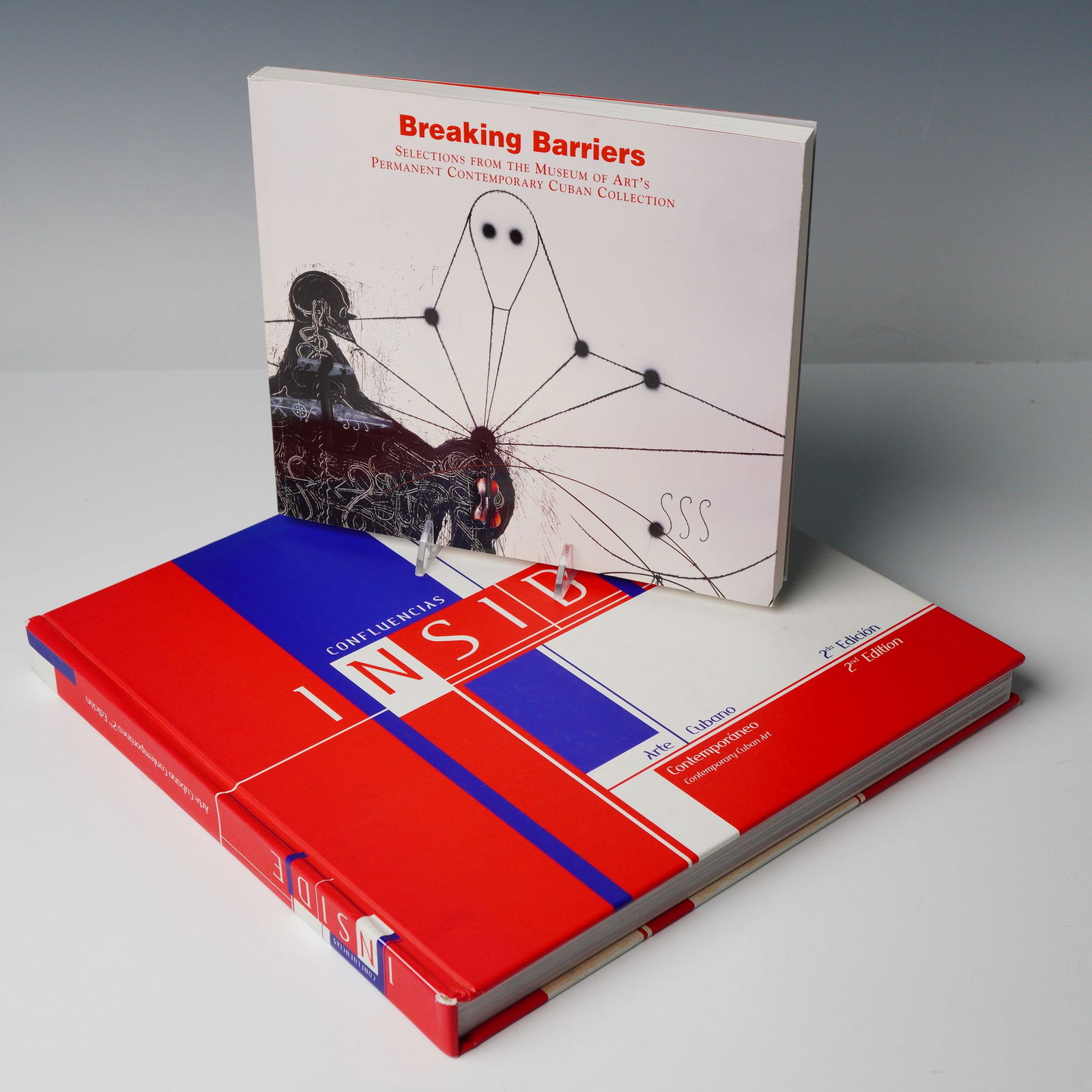 Two Vols: Breaking Barriers & Confluencias Cuban Art Books: A pair of exhibition catalogues focusing on Contemporary Cuban Art, published in square quarto format, comprising two distinct volumes. VOLUME I: Breaking Barriers. Selections from the Museum of Arts