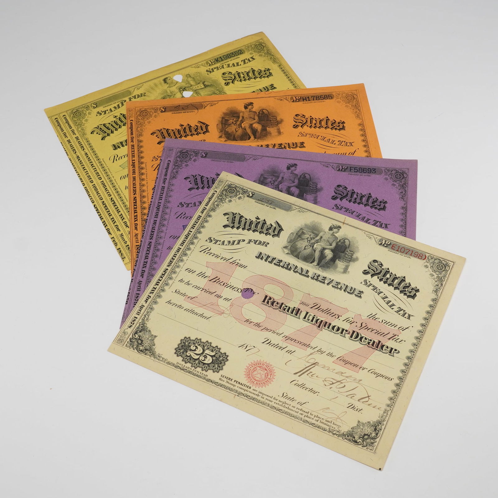 4pc Antique IRS Liquor and Tobacco Tax Stamps: This set of four antique U.S. Internal Revenue tax stamps from the 1880s was issued to business owners for liquor and tobacco sales. The stamps include various colors and feature unique handwritten de