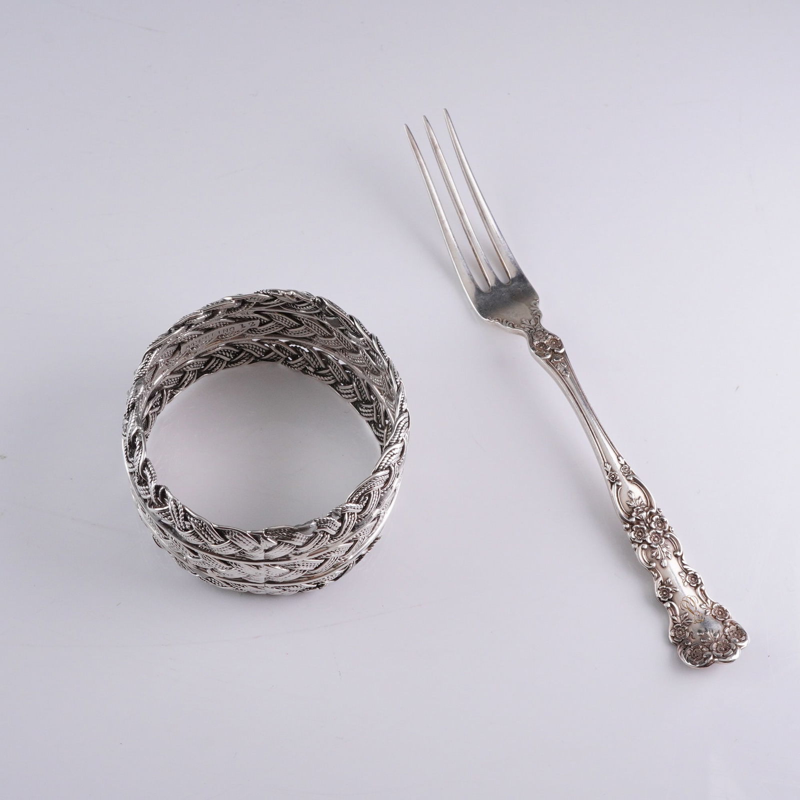 2 Antique Sterling Silver Lot - Victorian Fork & Braided Napkin Ring: A 2-piece lot of confirmed sterling silver accessories. Item 1 is a wide, highly textured napkin ring, constructed of multiple bands of woven or braided sterling silver, styled with intentional oxidat