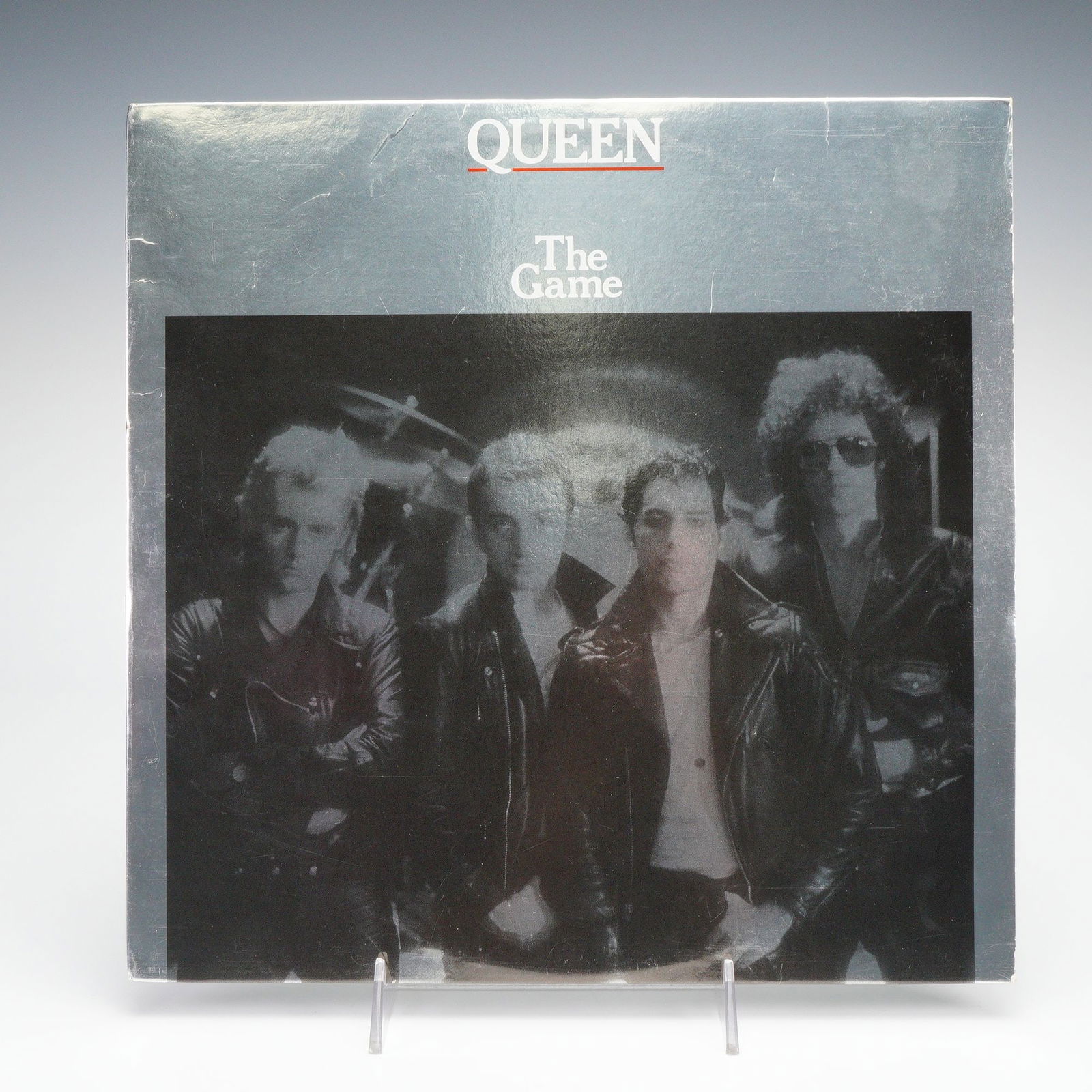 Queen Vinyl Record, The Game: Queen vinyl record of the album The Game, that includes Another One Bites the Dust and Crazy Little Thing Called Love; featuring its original silver jacket with band photo and track listing. Includes
