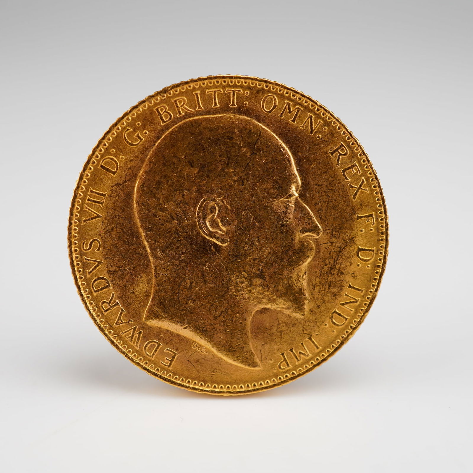 1907 1 Sovereign United Kingdom Edward VII Gold Coin: Featuring the uncrowned portrait of King Edward VII facing right on the obverse with surrounding legend, designed by George William de Saulles. The reverse displays Benedetto Pistrucci's classic depic