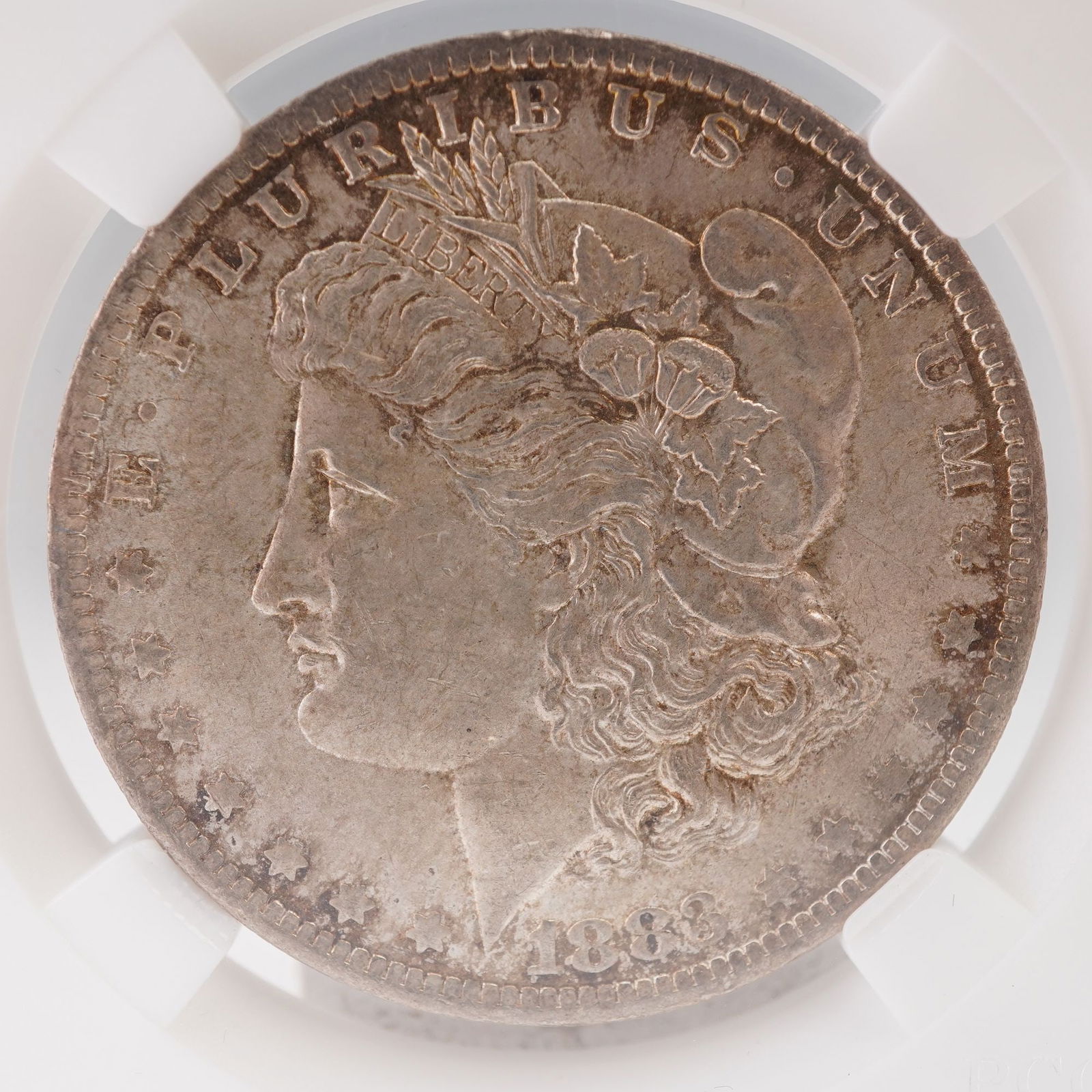 1883-O Morgan Silver Dollar: An 1883-O Morgan Silver Dollar, struck at the New Orleans Mint from an alloy of ninety percent silver and ten percent copper. The obverse bears the iconic George T. Morgan depiction of Liberty, crowne