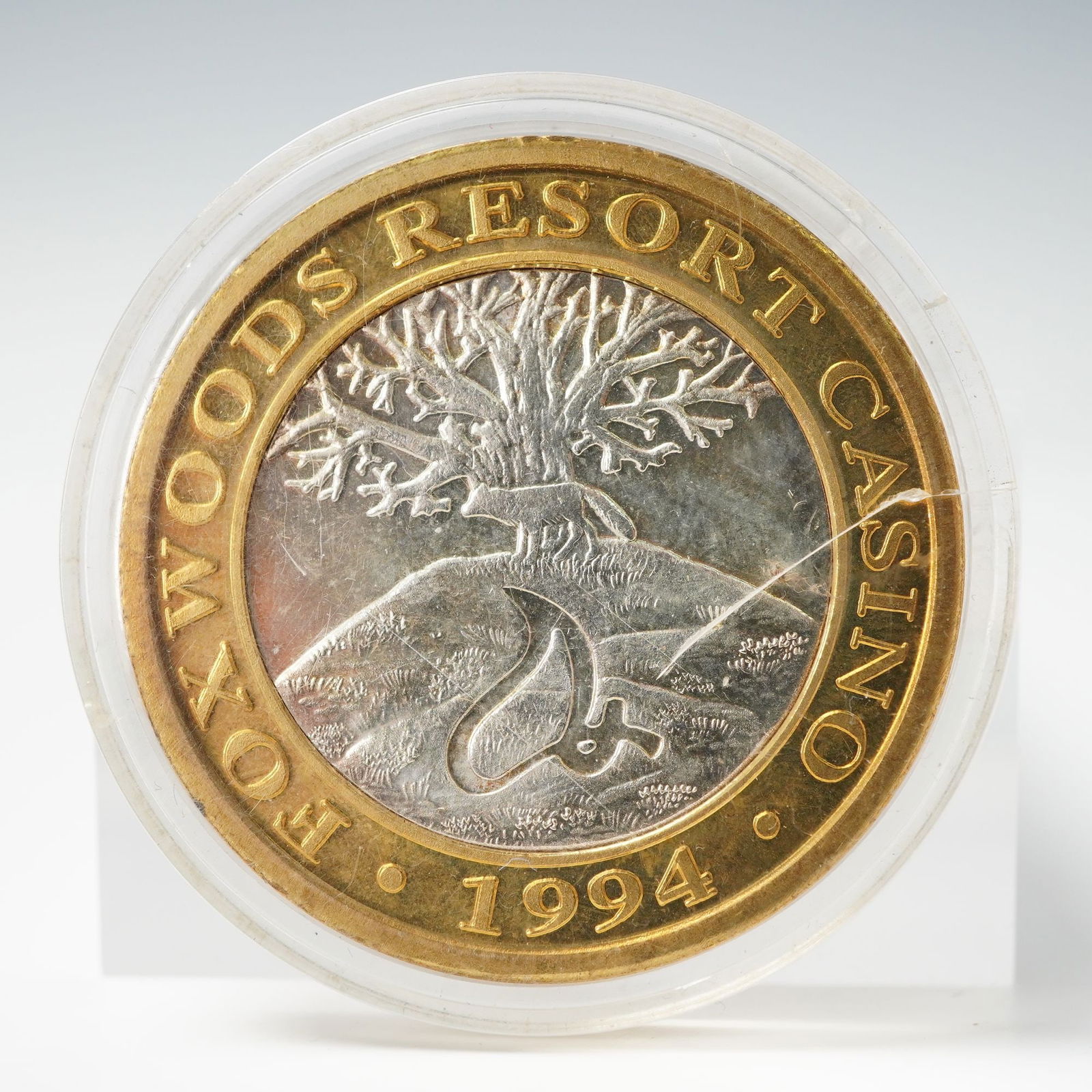 1994 Foxwoods Resort Casino State of Connecticut $10 Gaming Token: A limited edition 1994 Foxwoods Resort Casino ten dollar gaming token featuring fine silver center encircled by a brass outer ring. The obverse displays a fox atop a wooded hill beneath a sprawling tr