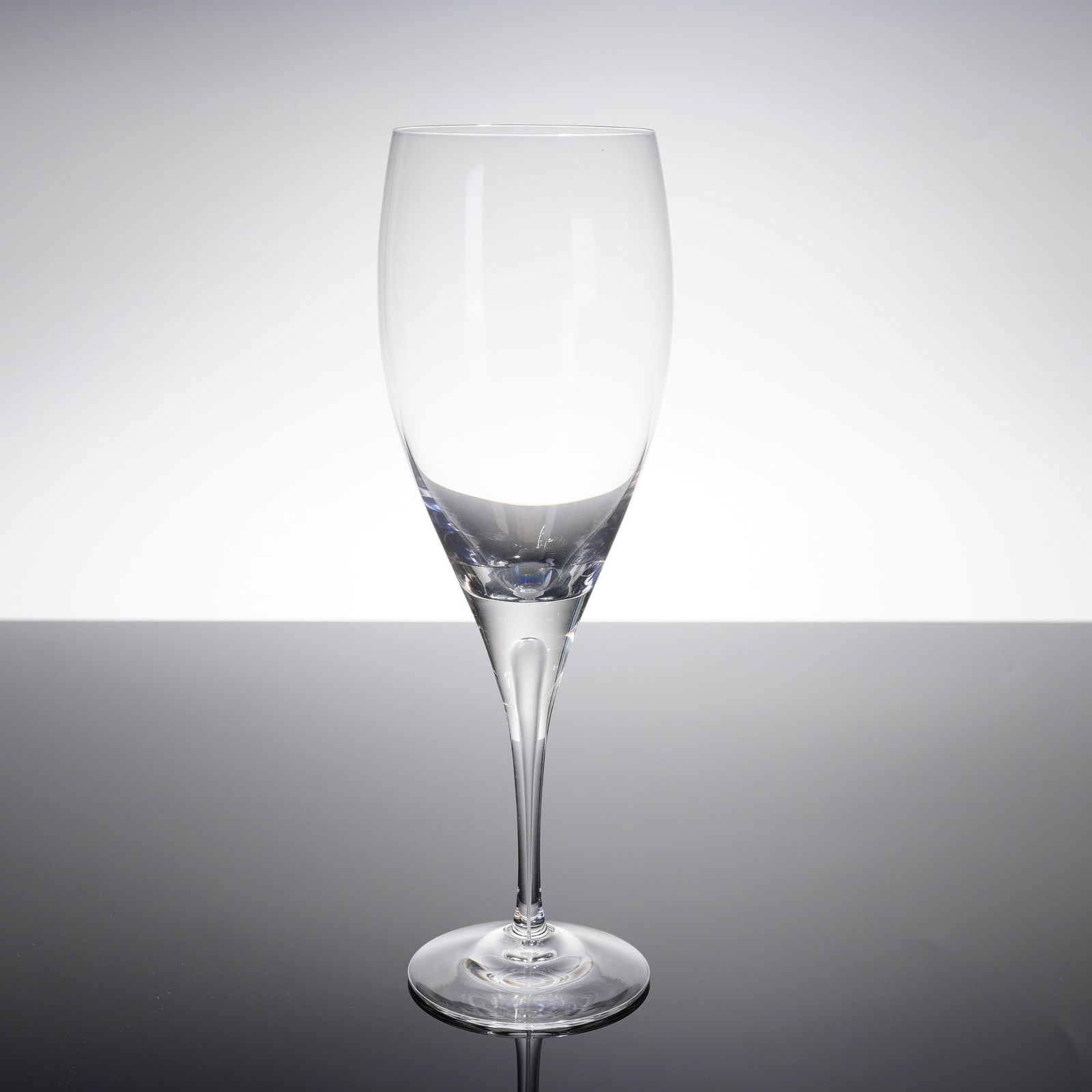 Orrefors Intermezzo Crystal Champagne Flute with Original Box: A single Orrefors Intermezzo crystal champagne fi?ute, accompanied by its original black retail box. The fi?ute features a modern, minimalist design characterized by a tapered, tulip-shaped bowl, a