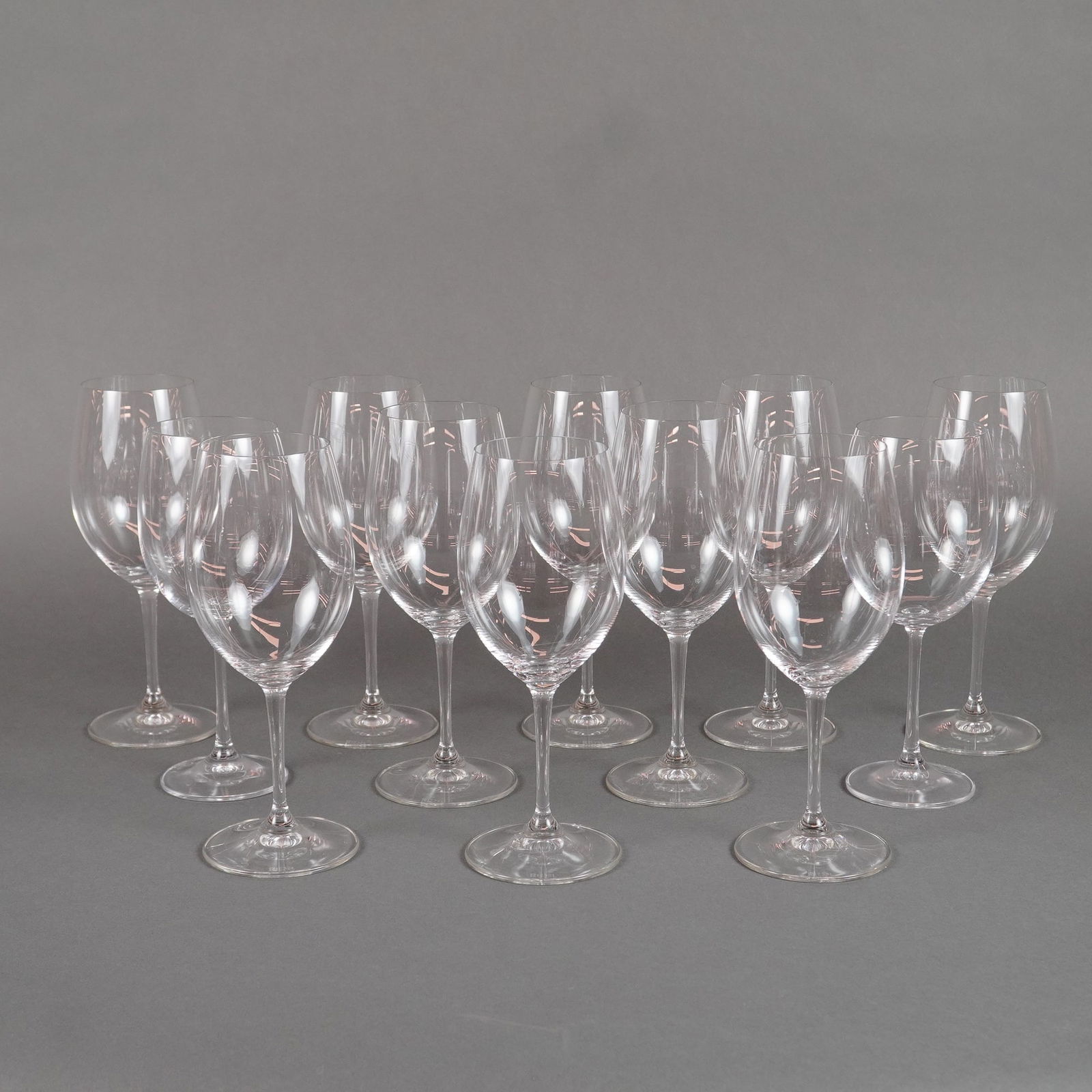 12pc Riedel Degustazione Crystal Red Wine Glasses: A collection of twelve Riedel Degustazione Red Wine stemware items. These clear crystal glasses feature a modern, functional design characterized by a wide, generous bowl suitable for red wine