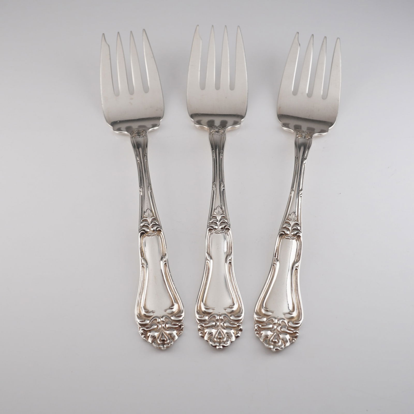 Three Amston Sterling Silver Champlain Pattern Salad Forks: A trio of sterling silver salad forks crafted by Amston in the Champlain pattern (also known as Princess Carlotta or Empress Carlotta). The flatware is executed in the Rococo Revival style, featuring