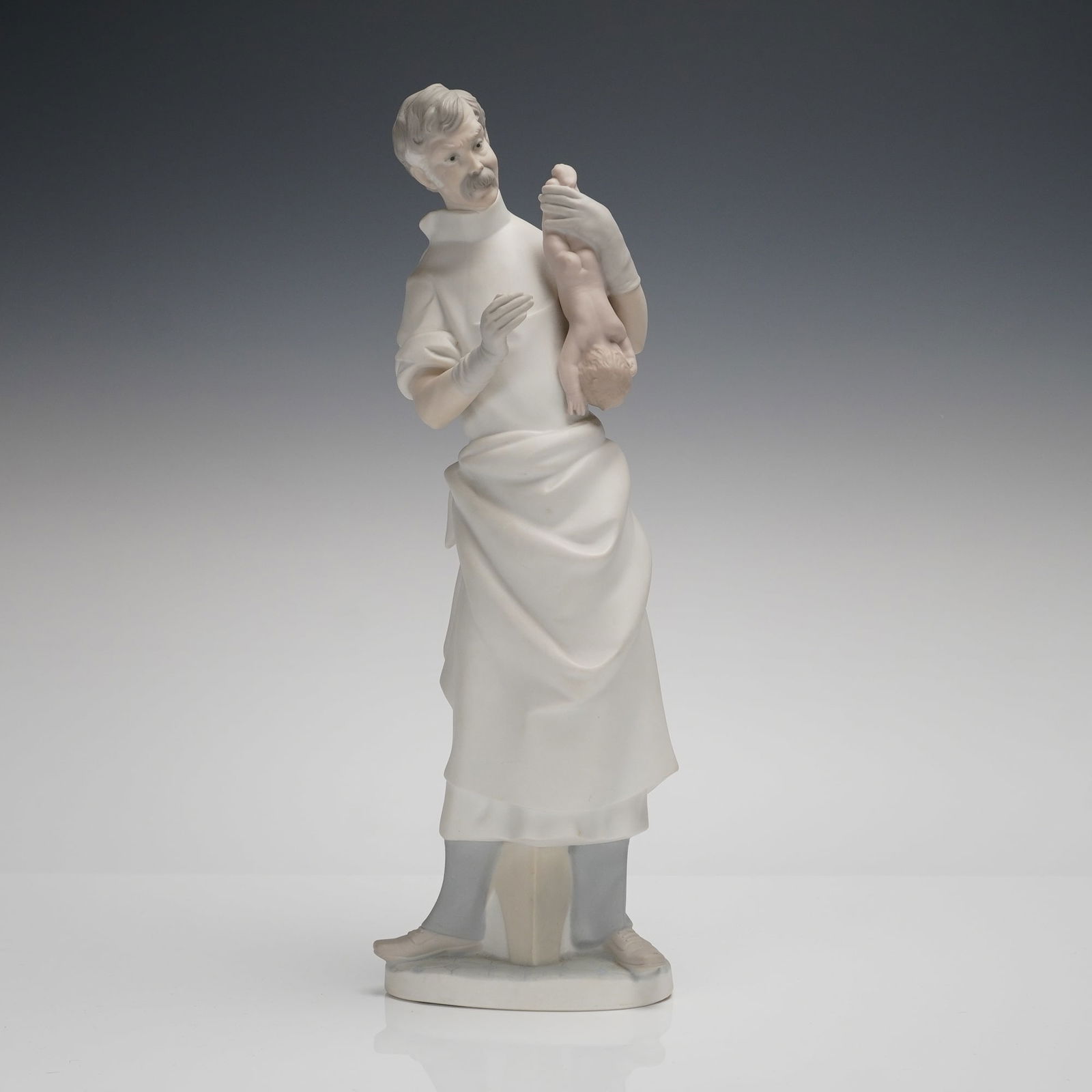 Lladro Matte Porcelain Sculpture Obstetrician Doctor with Baby Model 4763: A Lladro matte obstetrician sculpture, model number 4763, depicting a male medical professional, identified as an obstetrician or doctor, tenderly holding a newborn baby. The porcelain figurine