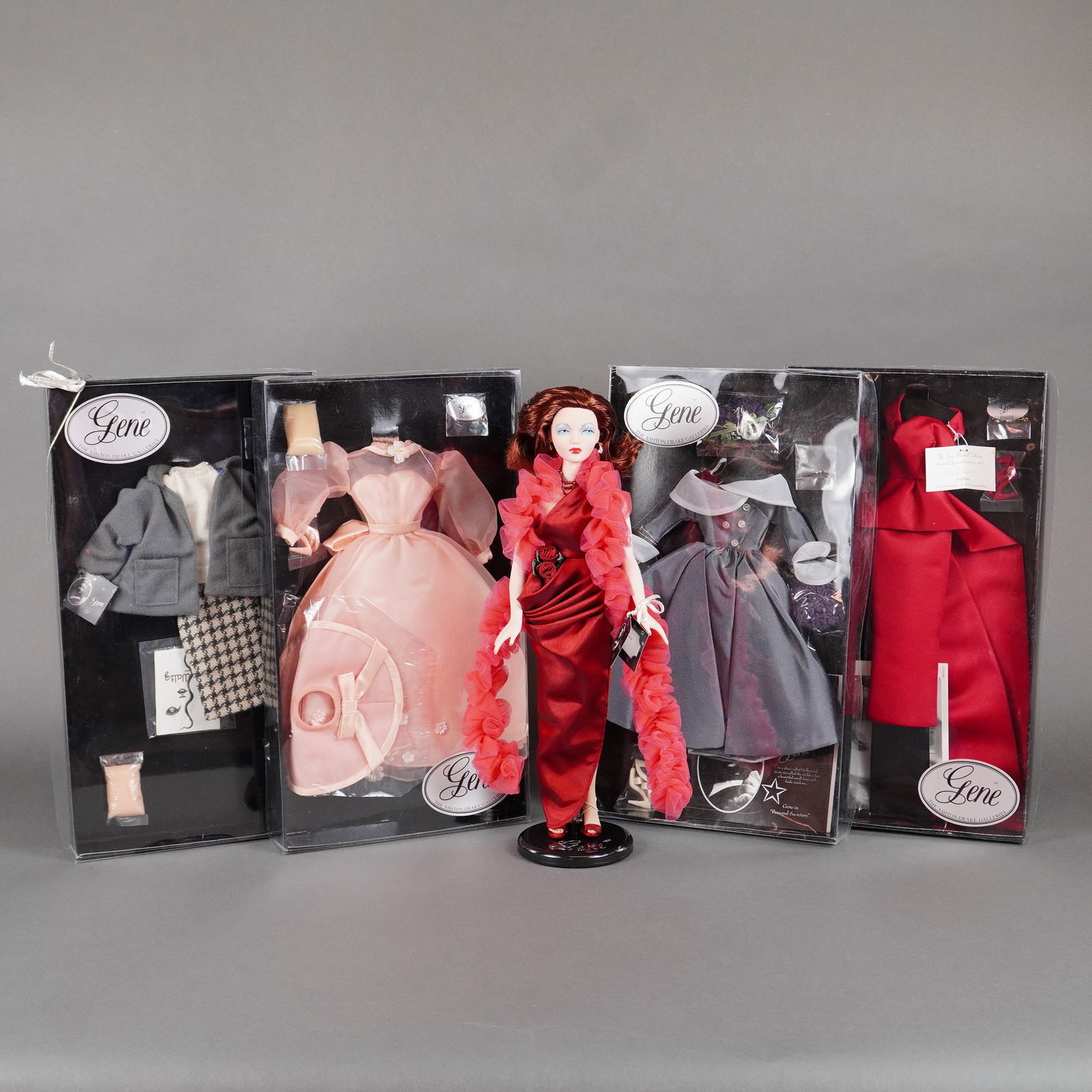 5pc Ashton Drake Galleries Gene "Red Venus" Doll & Fashion Ensembles: A collection of five pieces related to Mel Odom's Gene fashion doll line, manufactured by The Ashton-Drake Galleries, centered around the "Red Venus" doll. The lot includes the articulated plastic Gen