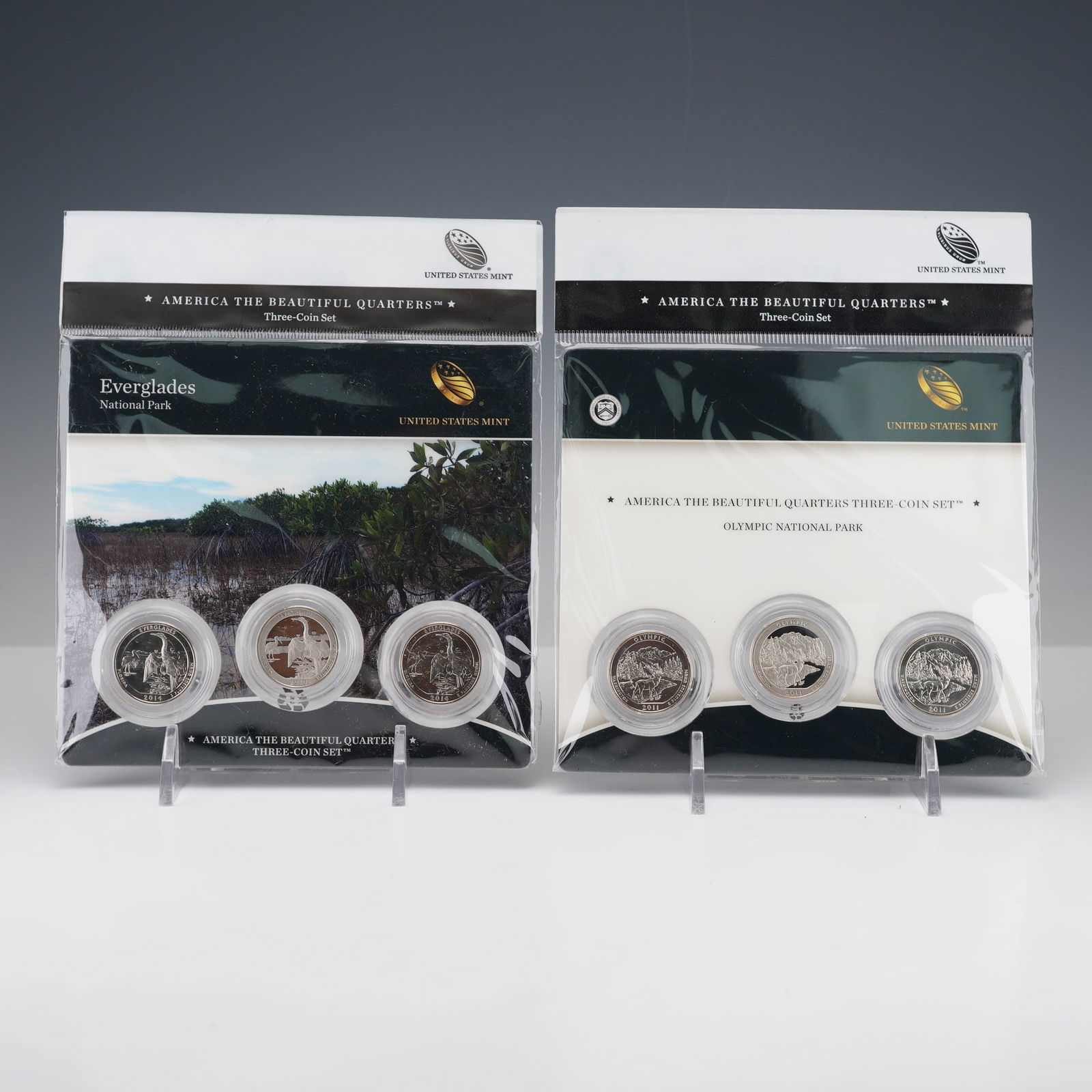 2pc 2011, 2014 America the Beautiful Three-Coin Quarters Sets: America the Beautiful Quarters three-coin sets, featuring Everglades National Park (2014) and Olympic National Park (2011). Each set includes three coins: a proof San Francisco mint quarter, an uncirc
