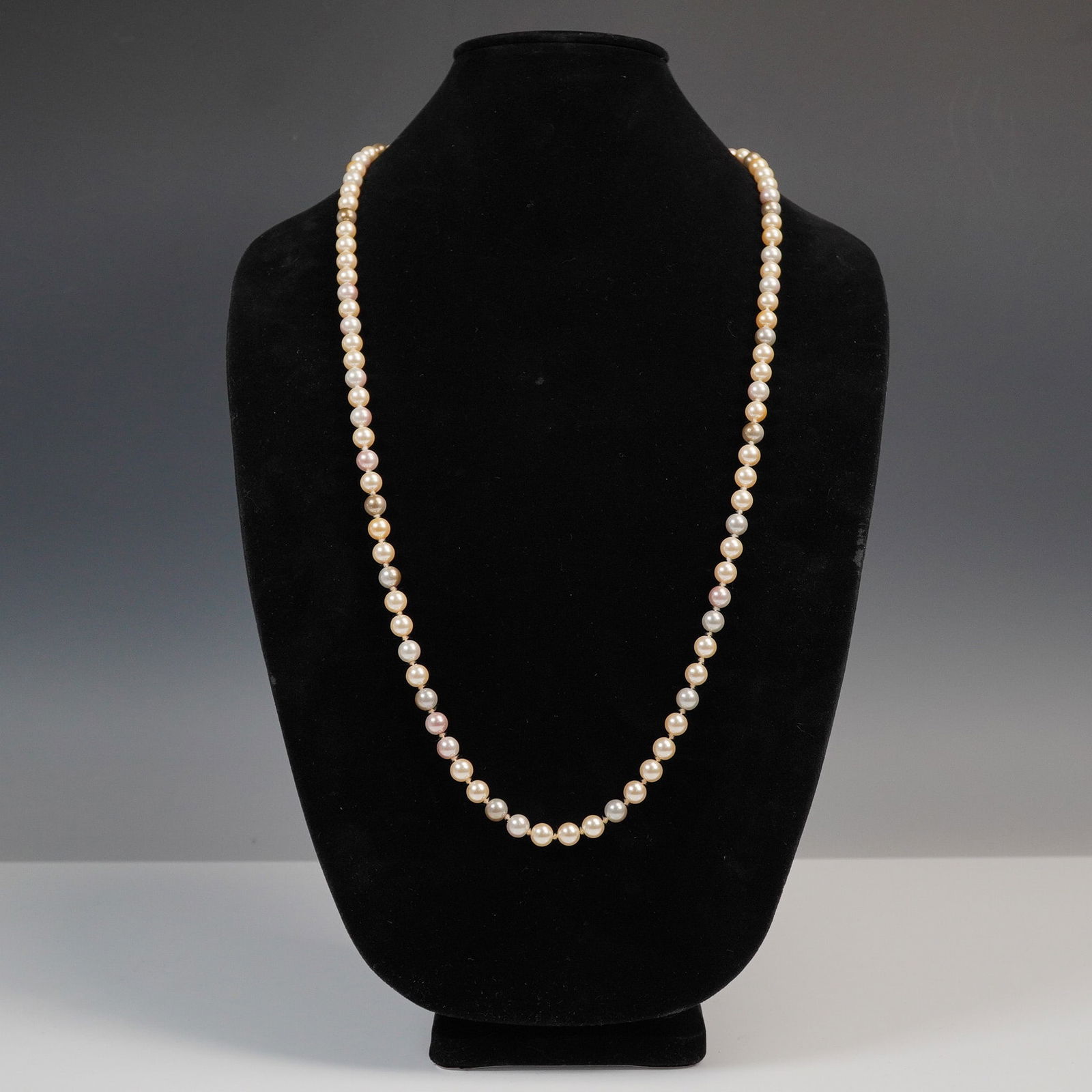 Costume Faux Pearl Necklace with Decorative Clasp: Costume faux pearl necklace featuring cream-tone beads and an ornate decorative clasp accented with green and clear rhinestones. Measures approximately 35.5"L from clasp to clasp. A charming vintage-s