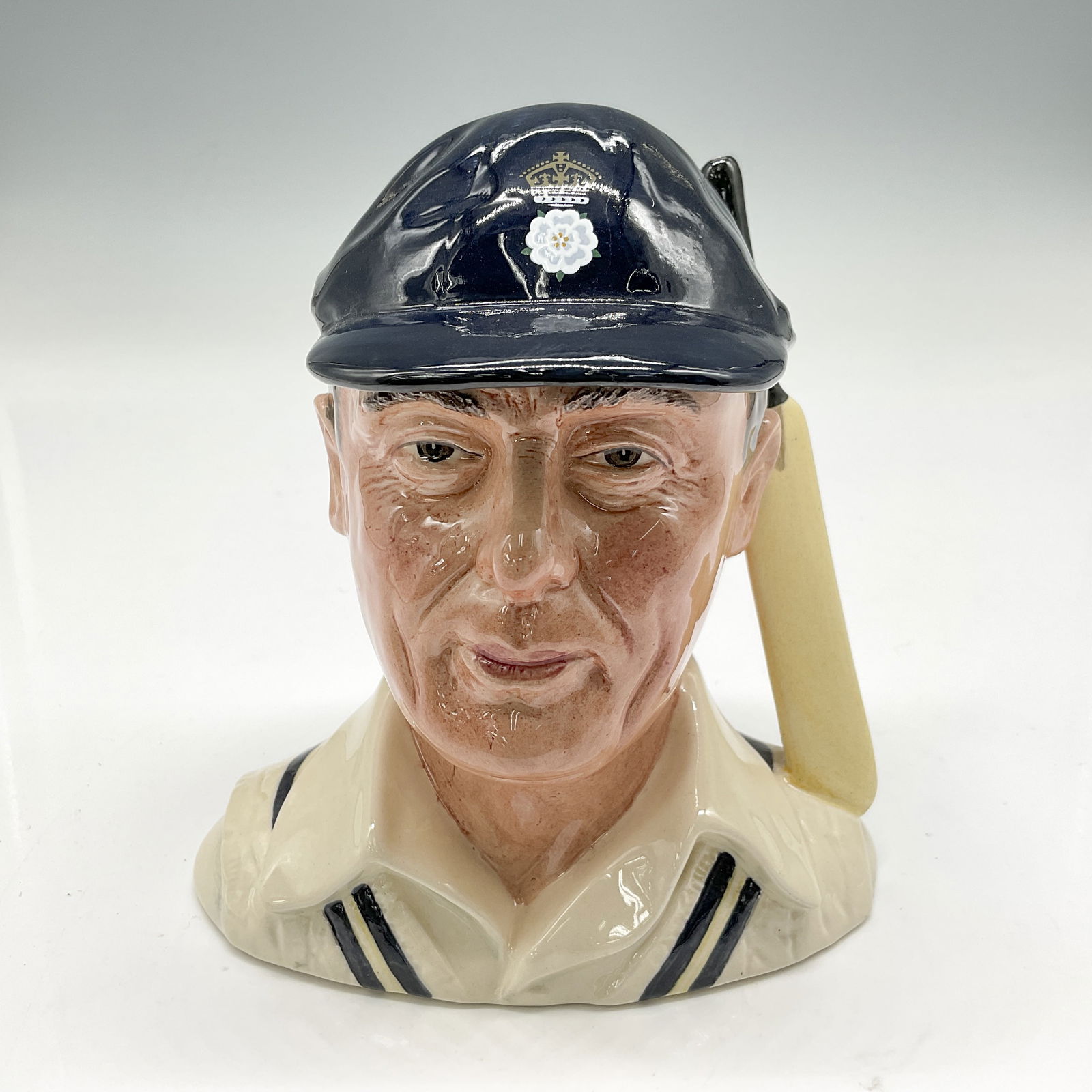 Hampshire Cricketer D6739 Small Royal Doulton Character Jug: Navy blue cap; cream sweater with navy/yellow stripes. Royal Doulton backstamp. Artist: Harry Sales Issued: 1985 Dimensions: 5"H Edition Number: 3083 of 5000 Country of Origin: England