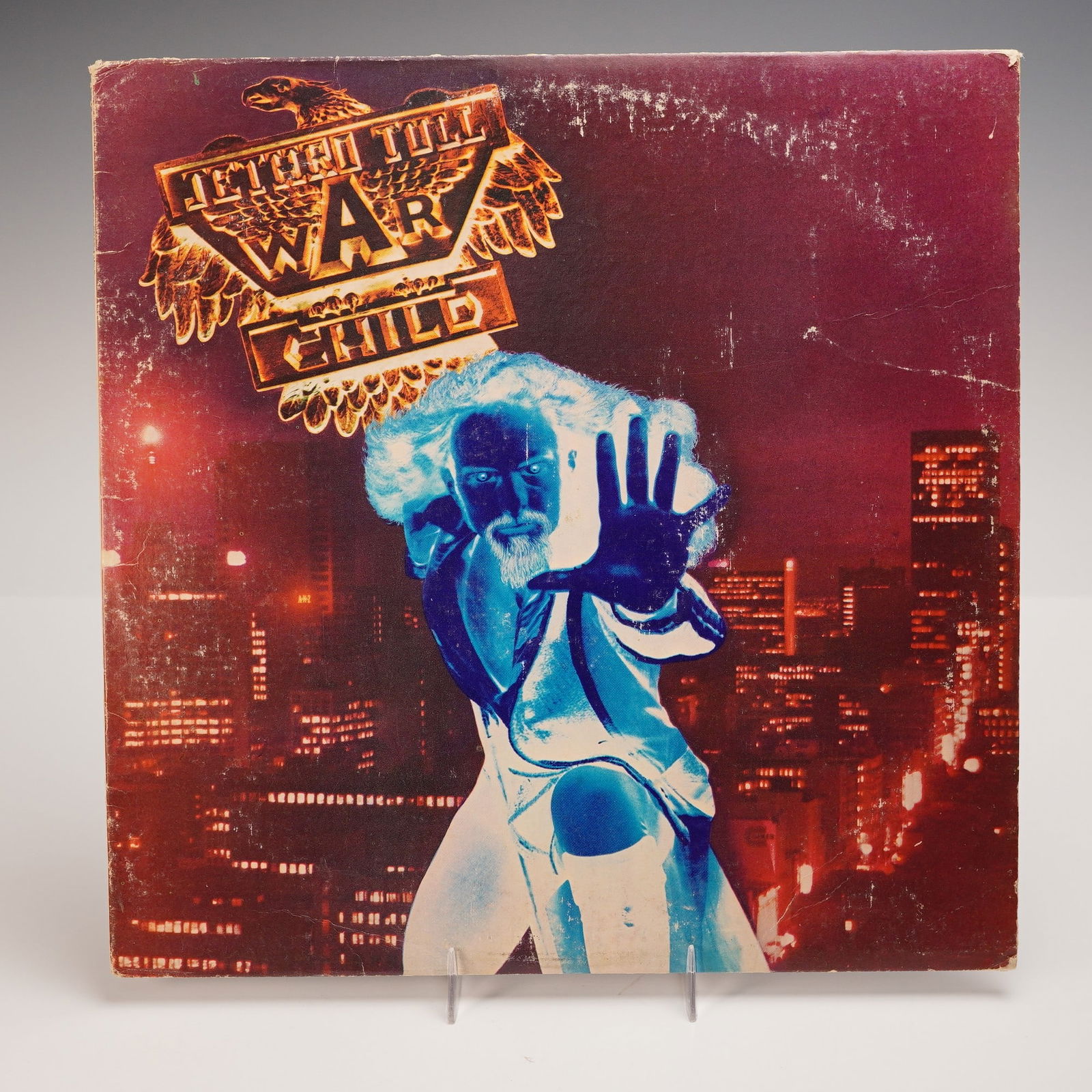 Chrysalis Records Jethro Tull Vinyl Record, War Child: An original pressing of "War Child" by Jethro Tull, released in 1974 by Chrysalis Records. The album's front cover features a surreal, photo-negative image of Ian Anderson set against a glowing metrop