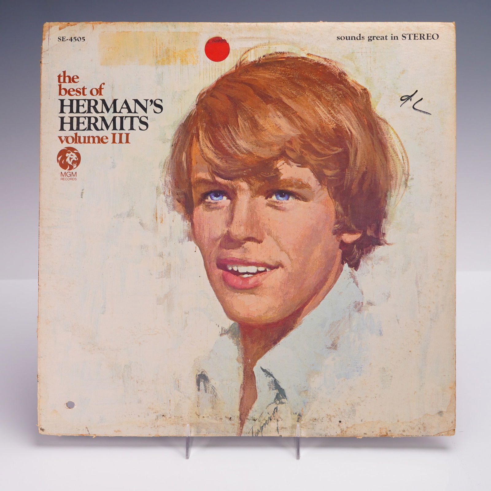 MGM Records The Best of Hermans Hermits Volume III Vinyl Record: A 1967 U.S. stereo pressing of "The Best of Herman's Hermits Volume III" LP vinyl album, released by MGM Records. The cover features a painted portrait of lead singer Peter Noone with striking blue ey