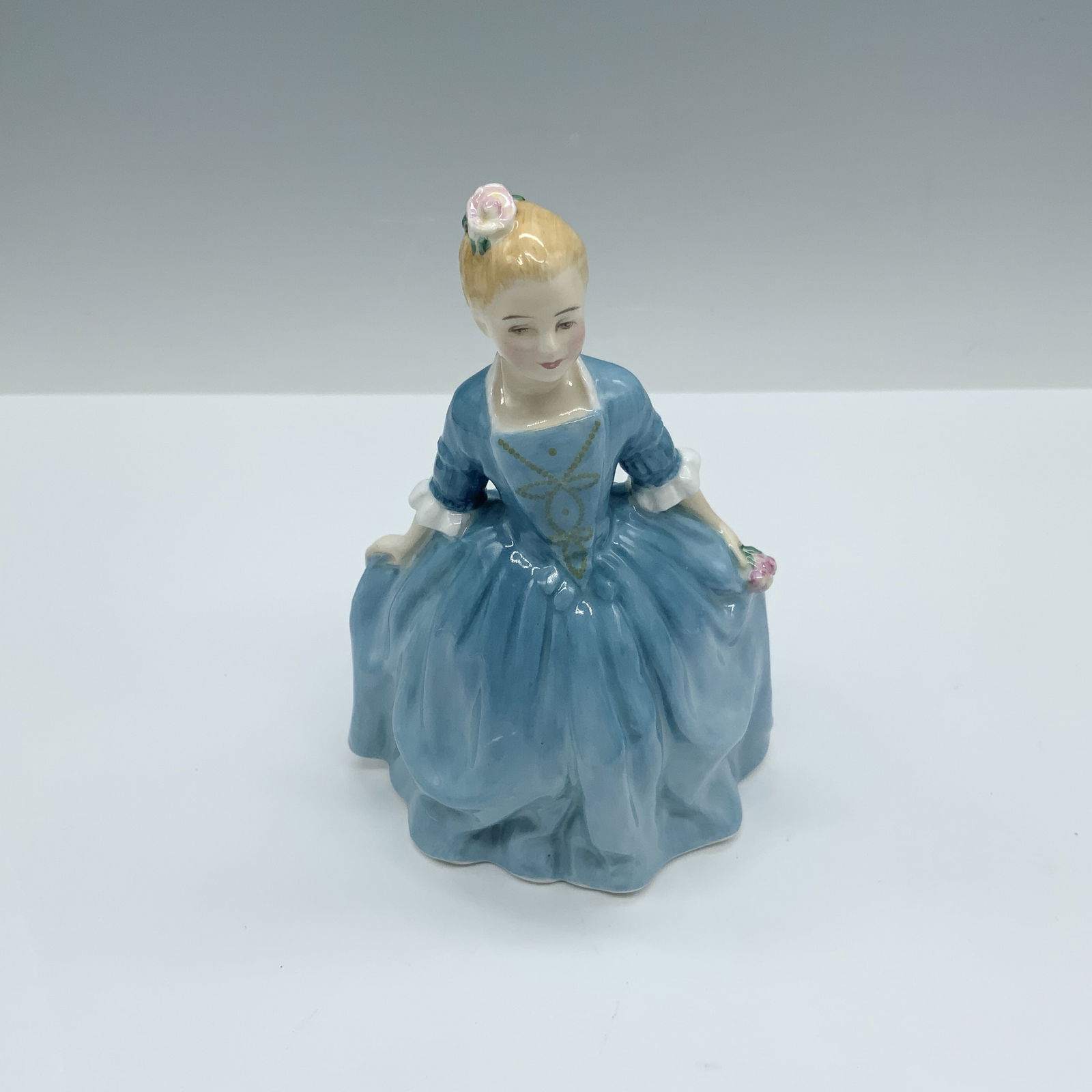 Child From Williamsburg HN2154 - Royal Doulton Figurine: Handmade and hand decorated glossy figure from the Figures of Williamsburg Series that depicts a young girl with blonde hair and a blue dress that tributes American History and culture as approval for